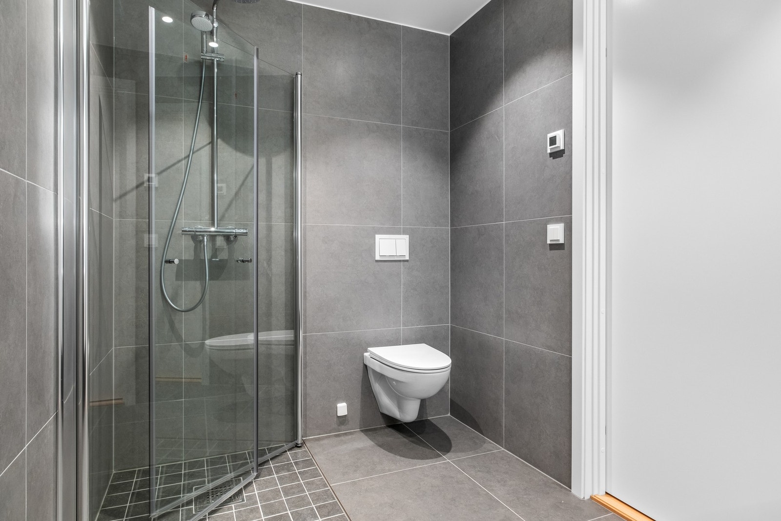 Badet har gulvvarme, vegghengt wc, dusjhjørne og opplegg for vaskemaskin. Galleribilde