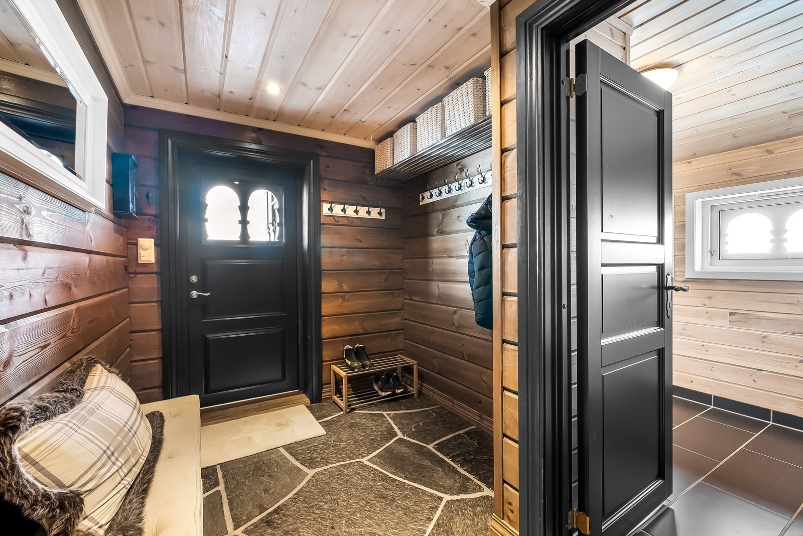 Velkommen til en innbydende entré med varme toner og praktiske løsninger. Galleribilde