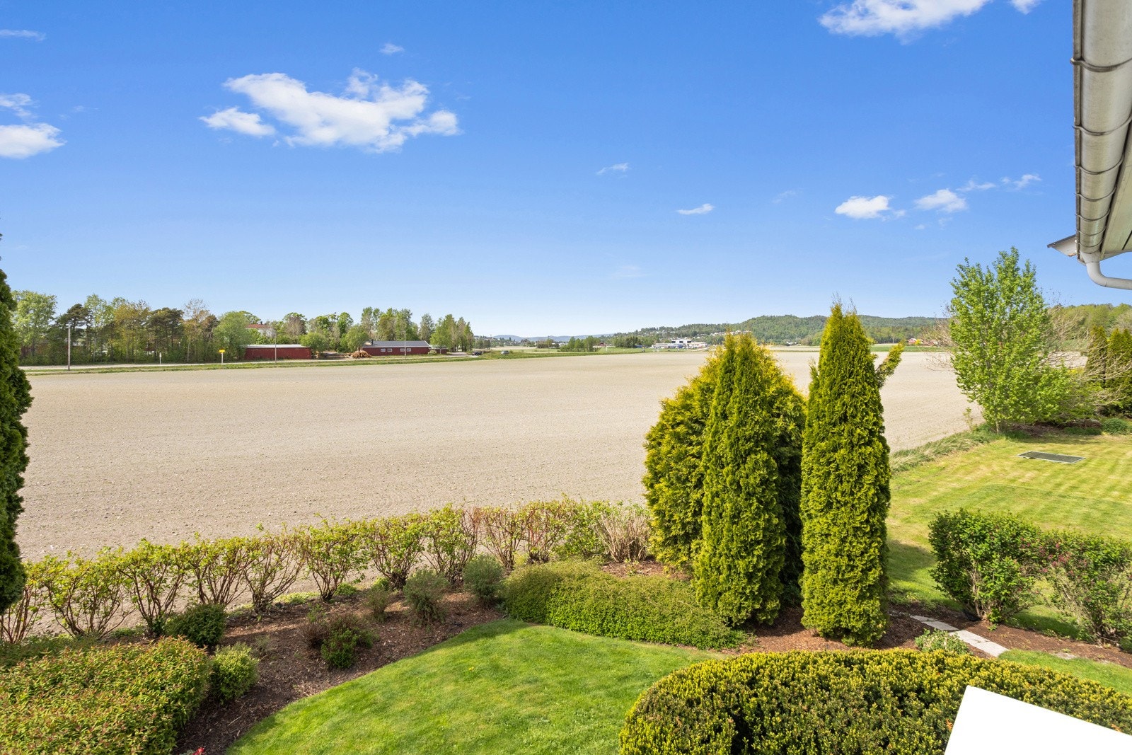 Pent opparbeidet med en kombinasjon av naturtomt, beplantet og gressplen. Grensende mot åpent jorde uten innsyn. Galleribilde