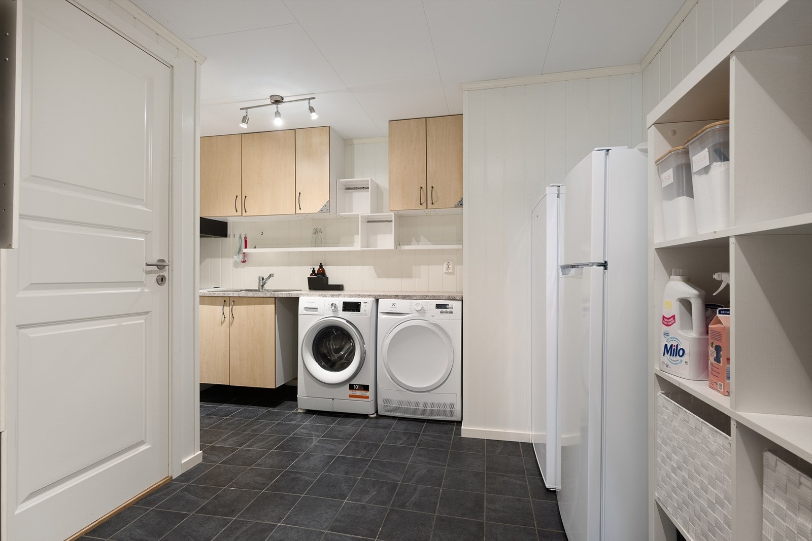 Lyst og romslig kjøkken/vaskerom med moderne fasiliteter. Praktisk innredning og god oppbevaringsplass gir effektiv klesvask i hverdagen. Galleribilde