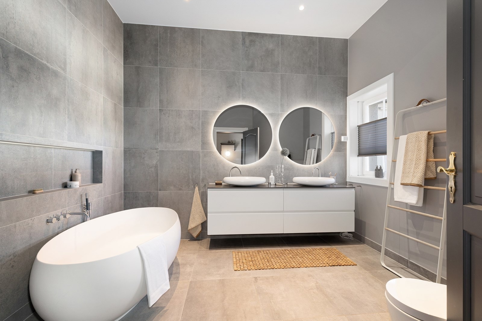 Stort bad med badekar, to servanter, speil og wc. Galleribilde