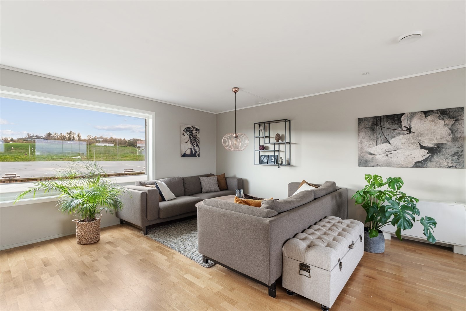 Lysmalt stue med parkett og store vindusflater Galleribilde