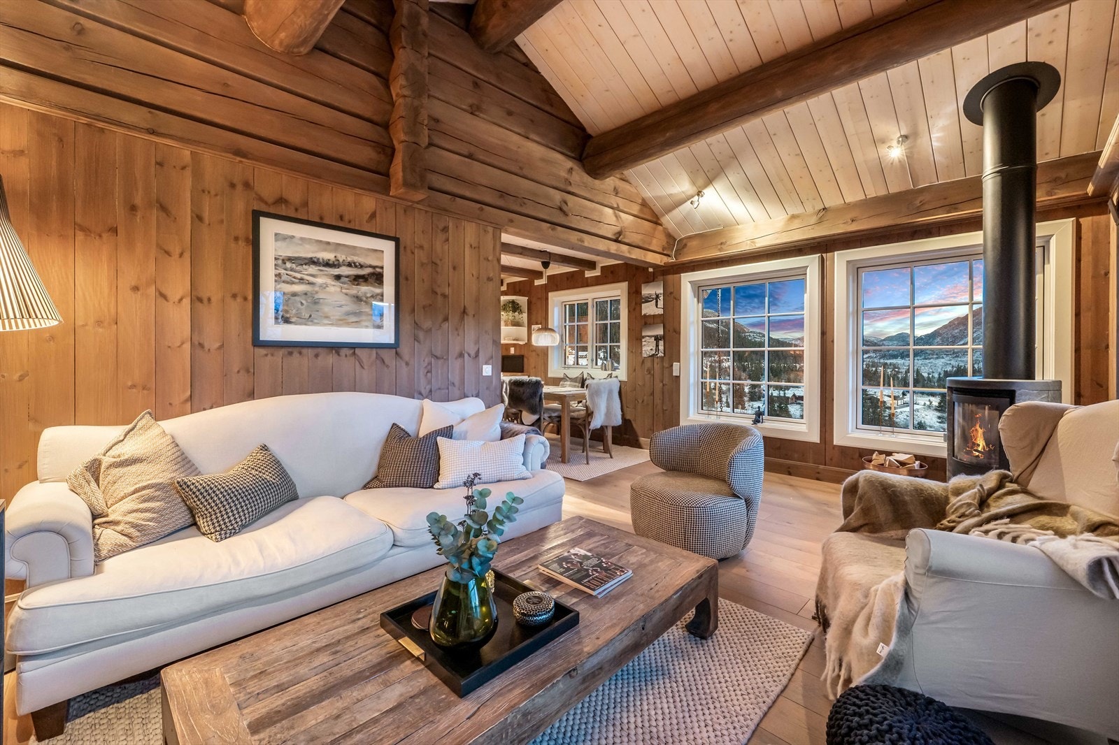 Kveldsstemning i stuen. Hytta har fantastisk takhøyde på opp mot 3,63 m og store vindusflater som skaper en luftig romfølelse. Galleribilde