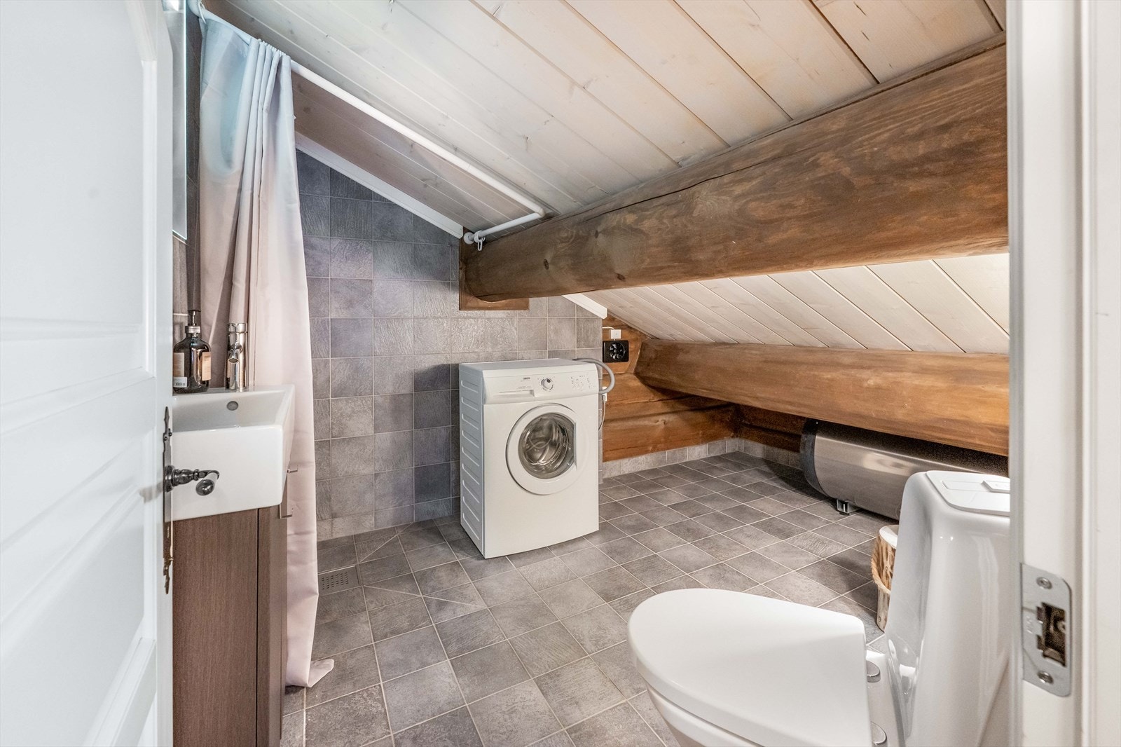 I 2.etg er det et ekstra baderom. Her er det et toalett, dusjhjørne, servant og opplegg for vaskemaskin. Det er gulvvarme, mekanisk avtrekk og en varmtvannsbereder på ca. 200 liter. Galleribilde