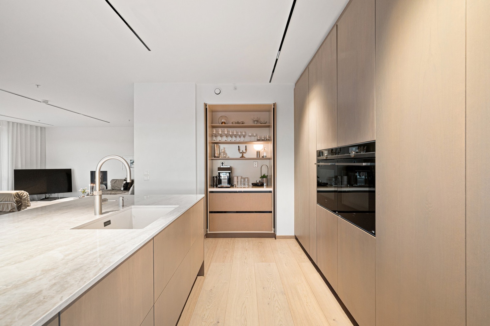 Kjøkkeninnredning med plane fronter og benkeplater av stein. Galleribilde