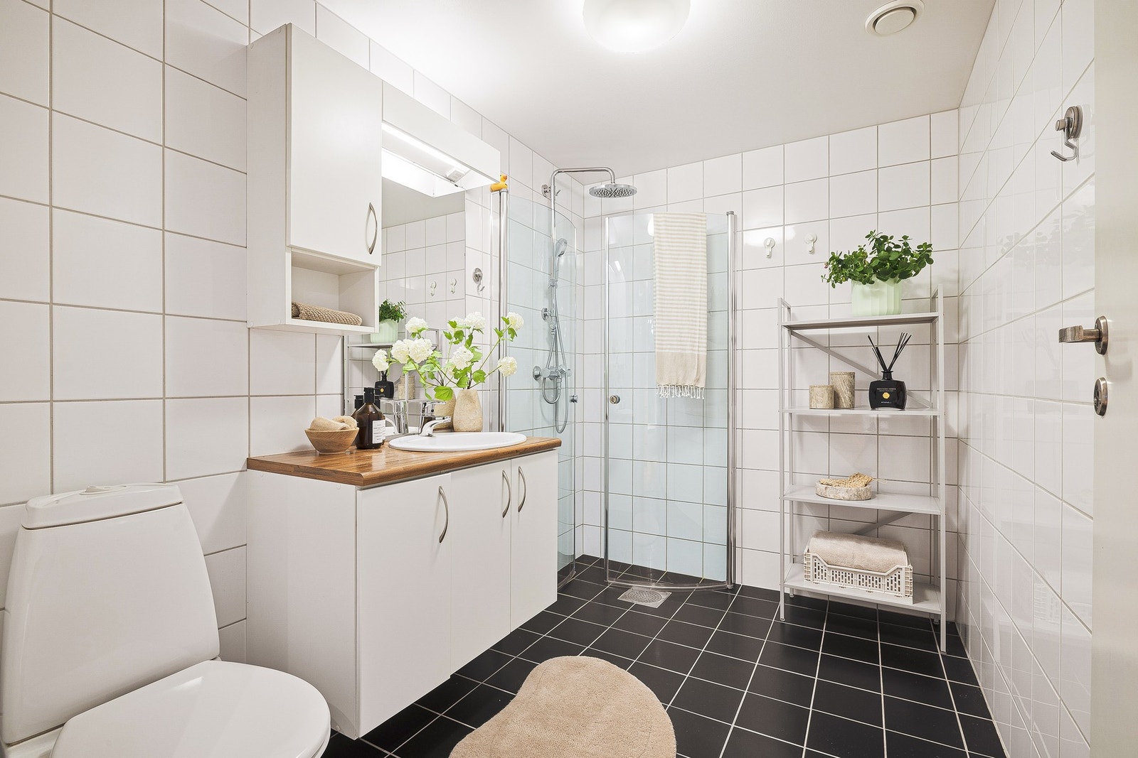 Pent og tidløst helfliset bad med alt du trenger - Med varmtvann fra fjernvarmeanlegget går du aldri tom for varmtvann Galleribilde