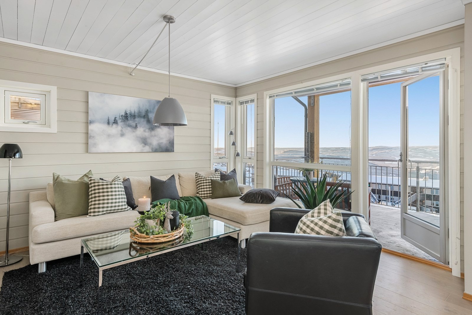 Direkte utgang til solrik, overbygget veranda fra stue/kjøkken med fritt utsyn mot omkringliggende naturlandskap. Galleribilde