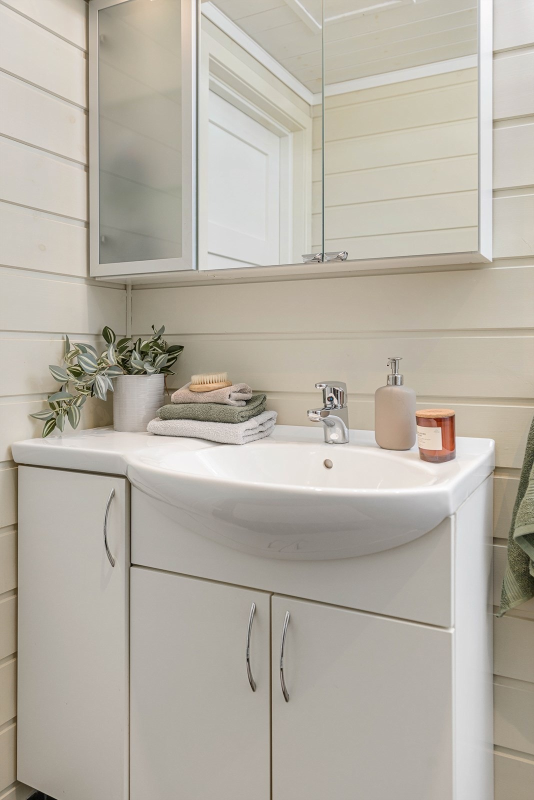 Badet er innredet med baderomsinnredning med skuffer, dusjhjørne med innfellbare glassvegger. Det er også opplegg for vaskemaskin. Galleribilde