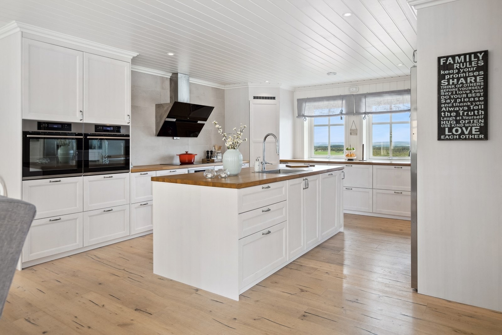 Hvitt profilert kjøkken med heltre benkeplate. Galleribilde