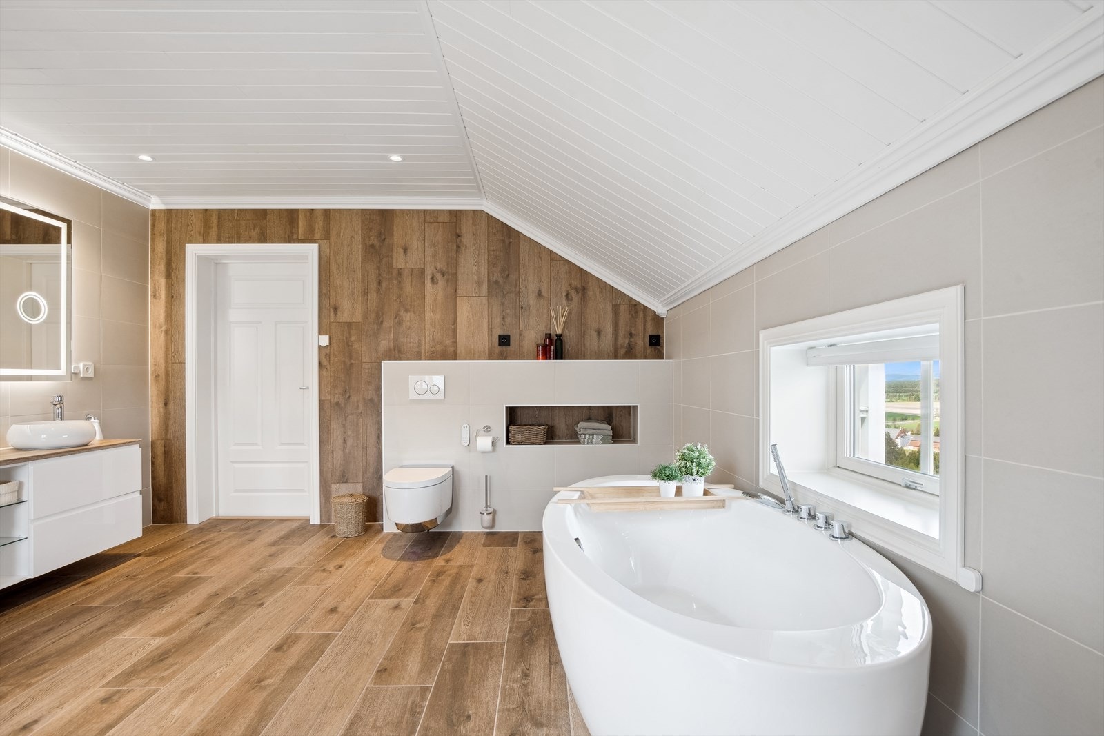 Badet inneholder vegghengt dusjtoalett og badekar. Galleribilde