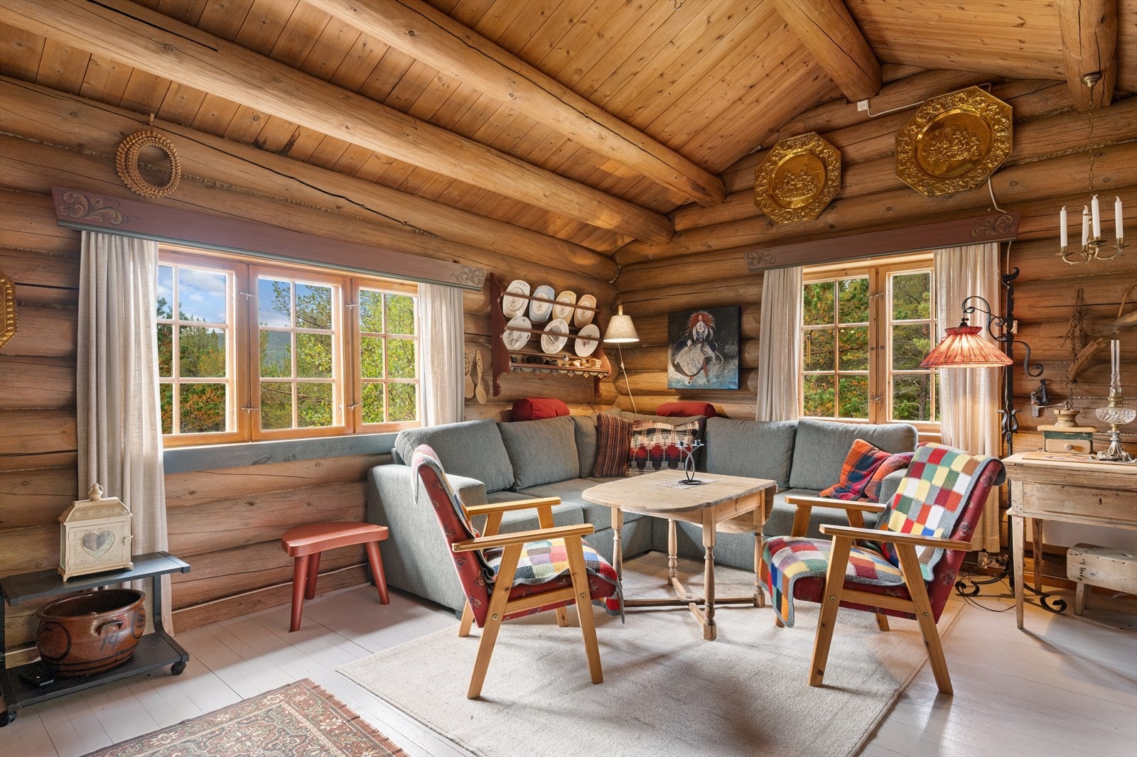 Stua er møblert med sofa, lenestoler, spisestue, skap mm. Galleribilde