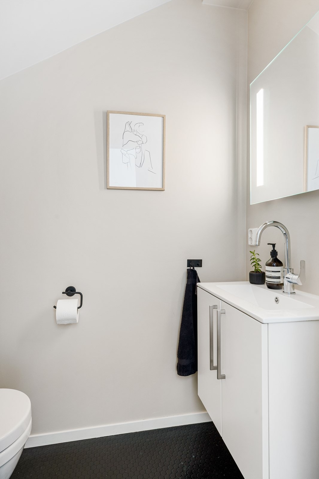 Toalettrom med vegghengt toalett og servant med underskap. Galleribilde