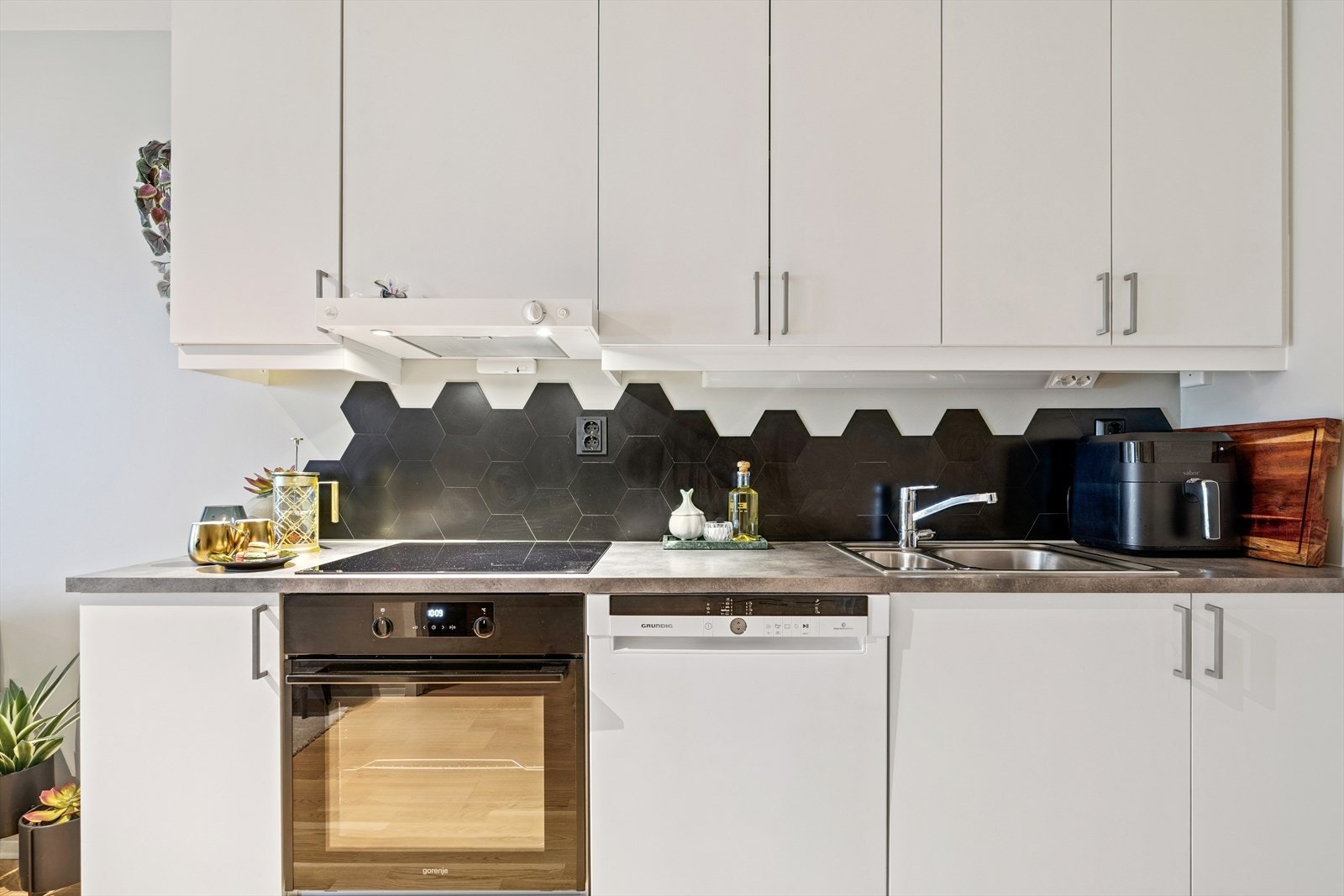 Det er lys mellom over- og underskap, og god plass til lagring i skap, skuffer og benkeplass. Galleribilde