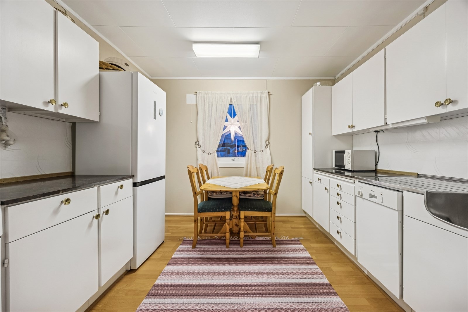 Det er utstyrt med frittstående kjøl/fryseskap, oppvaskmaskin, platetopp, stekeovn og kjøkkenventilator med avtrekk ut. Kjøkkeninnredningen er eldre med noe slitasje. Galleribilde