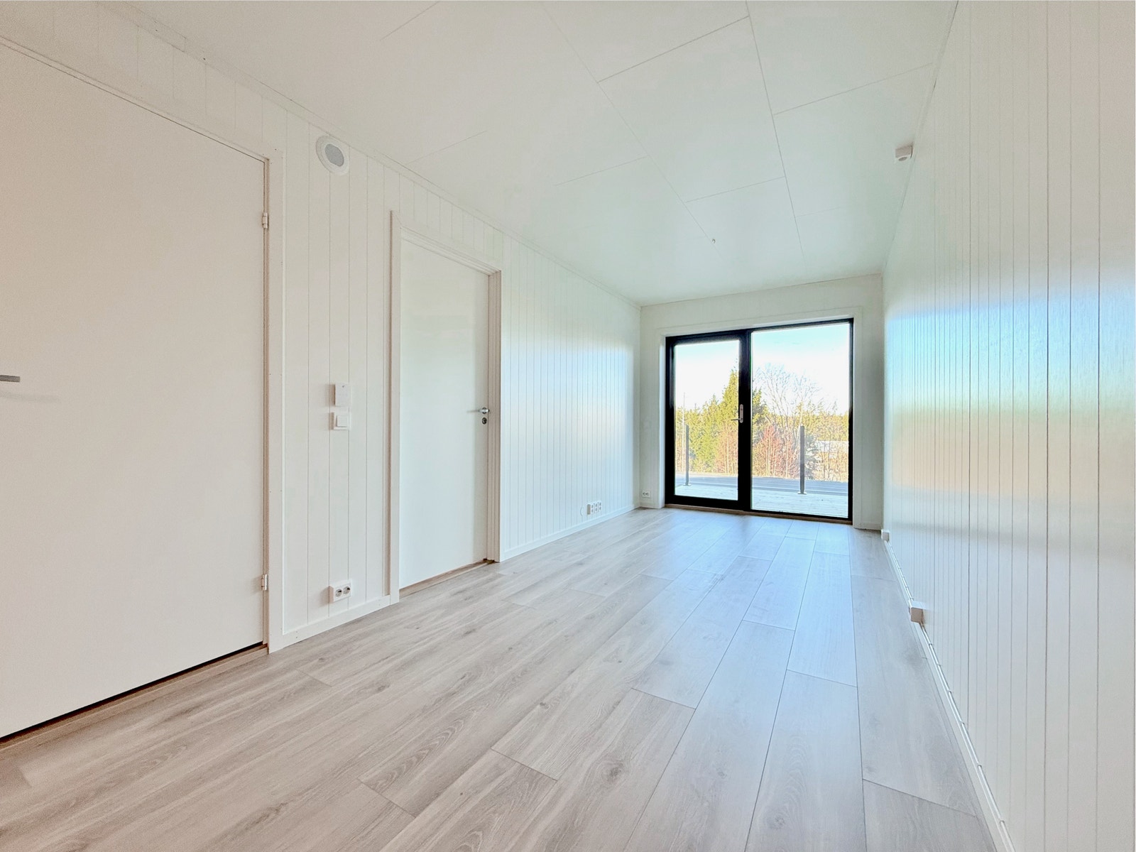 Lys stue med adkomst til øvrige rom og utgang til terrasse Galleribilde