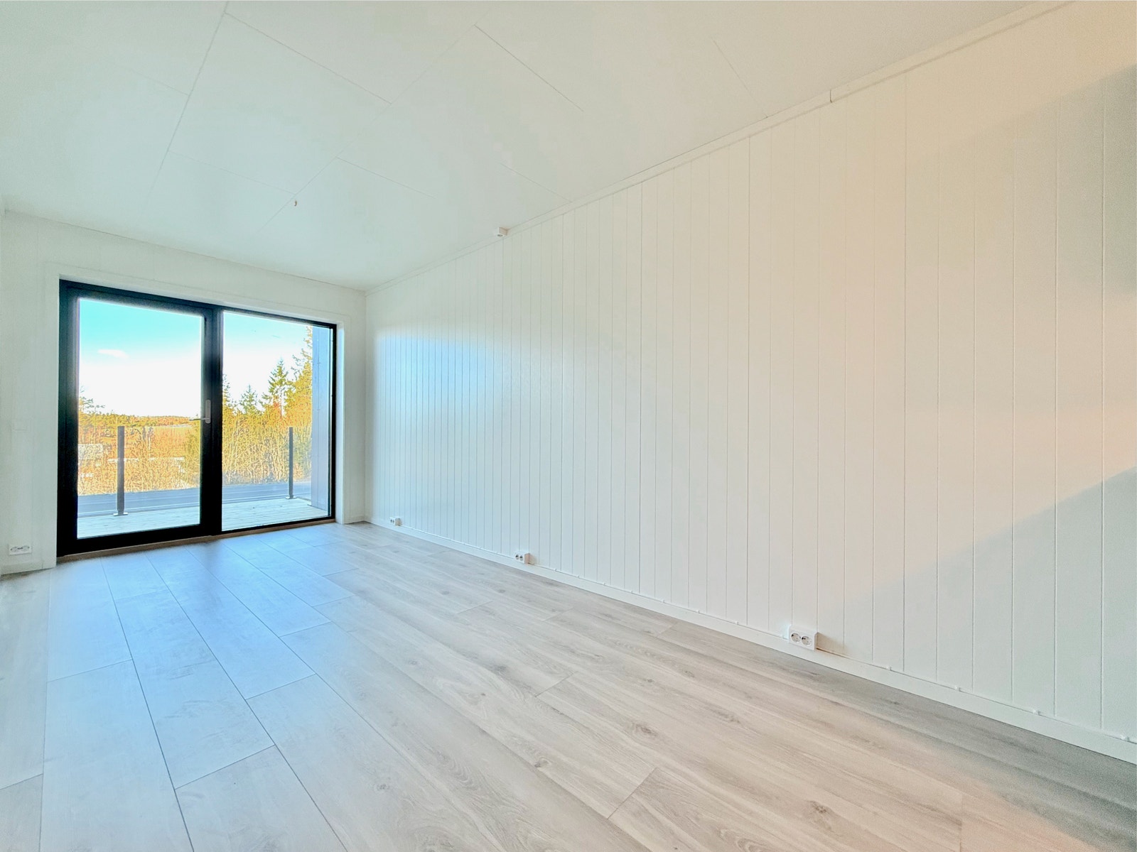 Stue med lyse overflater og utgang til privat terrasse Galleribilde