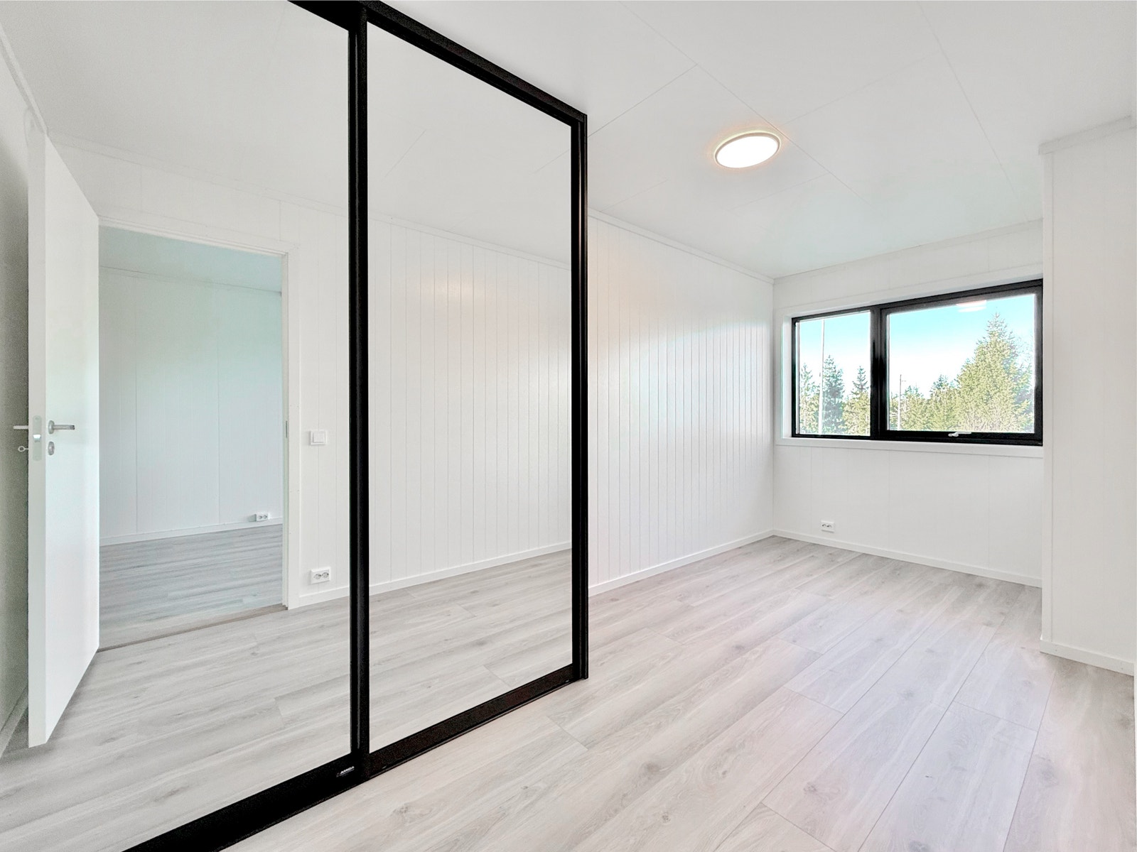 Soverom 1 med speilskyvedørsgarderobe og stort vindu Galleribilde
