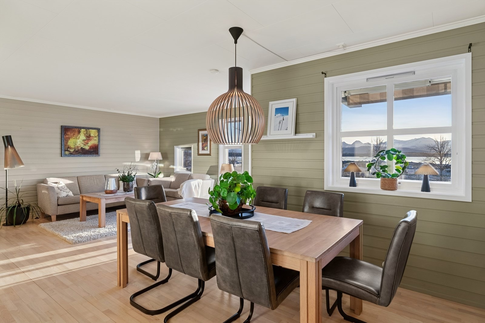 Spiseplassen er romslig og gir god plass til et stort spisebord med sitteplasser for gjester. Den åpne løsningen mot kjøkken og stue skaper en sosial atmosfære, perfekt for hyggelige middager og sammenkomster. Galleribilde