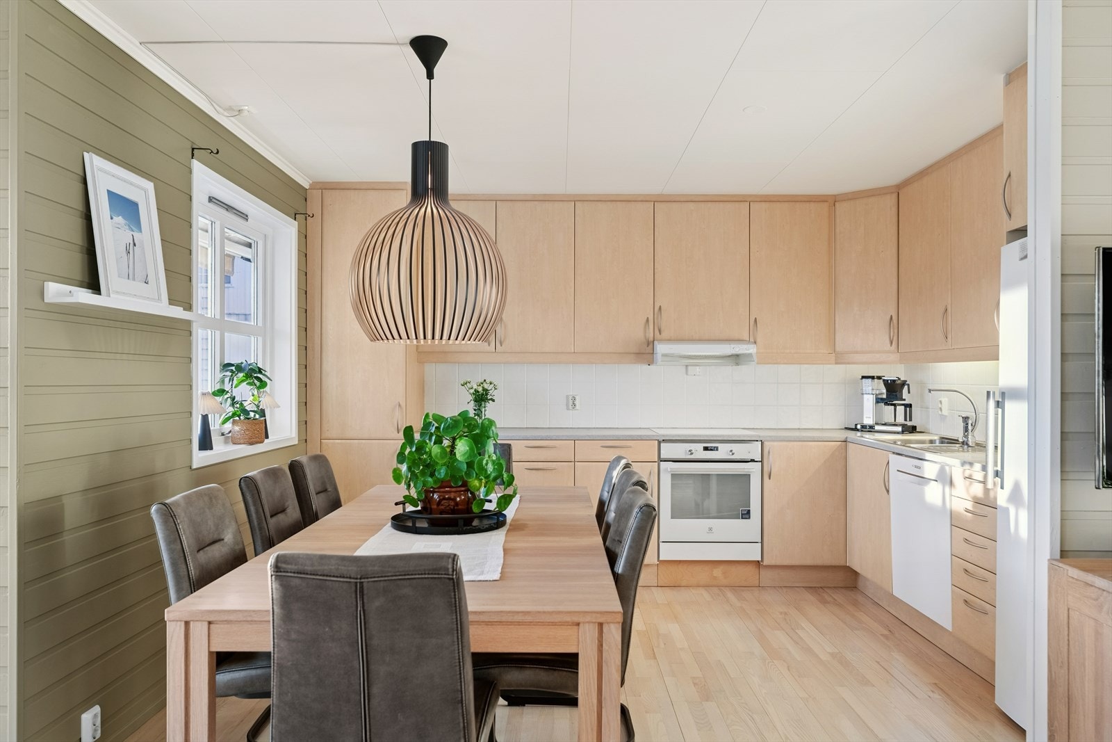 Kjøkkenet er praktisk og stilrent med skapfronter i glatte overflater, laminat benkeplate og takhøye overskap. Galleribilde