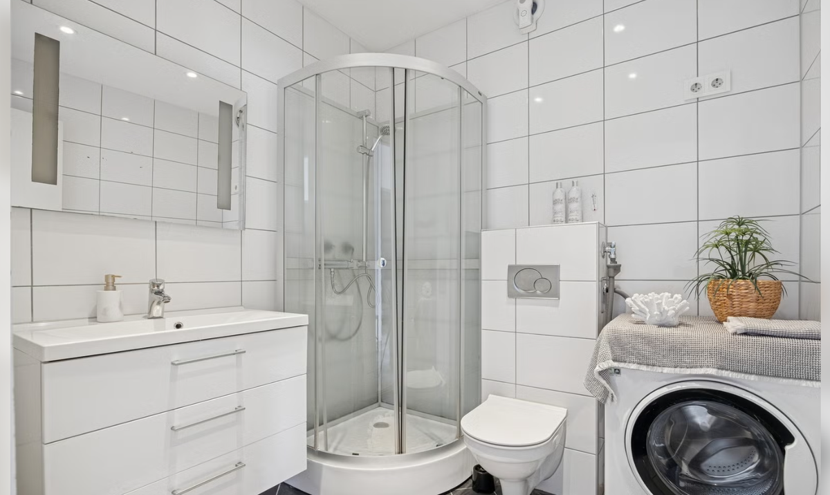 Bad med dusj, vegghent wc og vaskemaskin Galleribilde