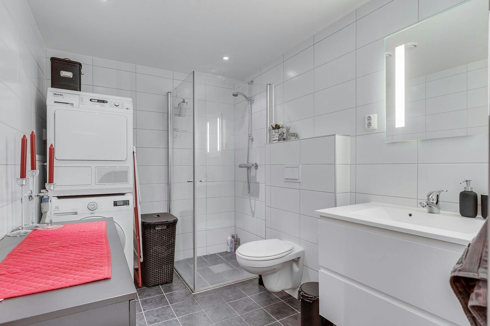 Flislagt bad med alle fasiliteter. Vaskemaskin og tørketrommel medfølger. Galleribilde