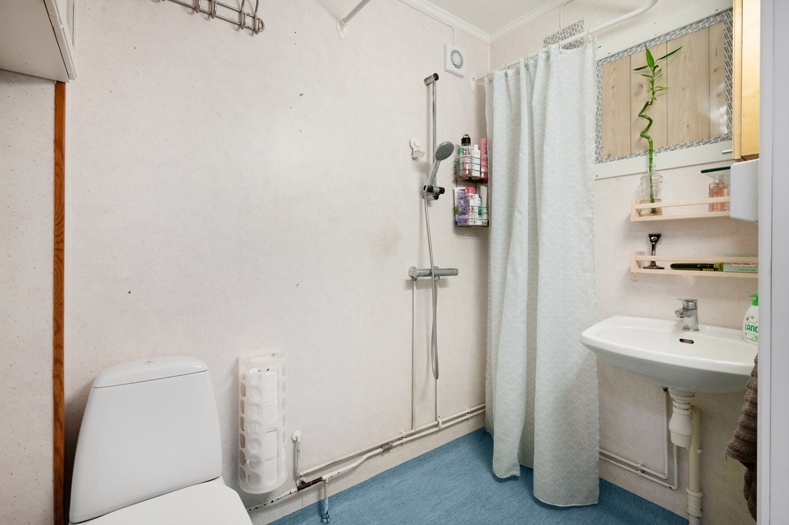 Eldre bad bestående av gulvmontert toalett, dusj m/forheng og servant. Galleribilde