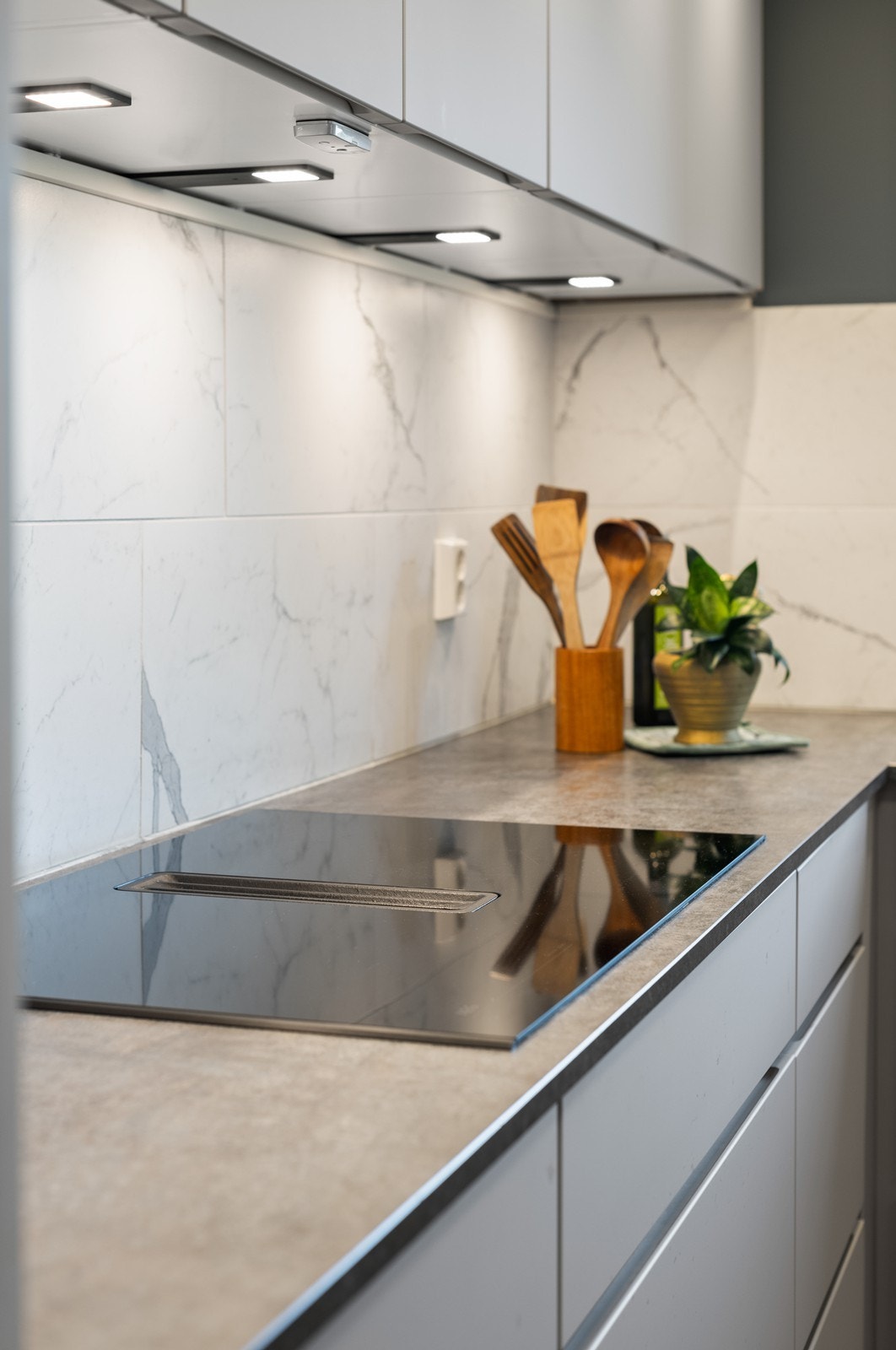 Det integrert koketopp og moderne fliser mellom benk og overskap. Galleribilde