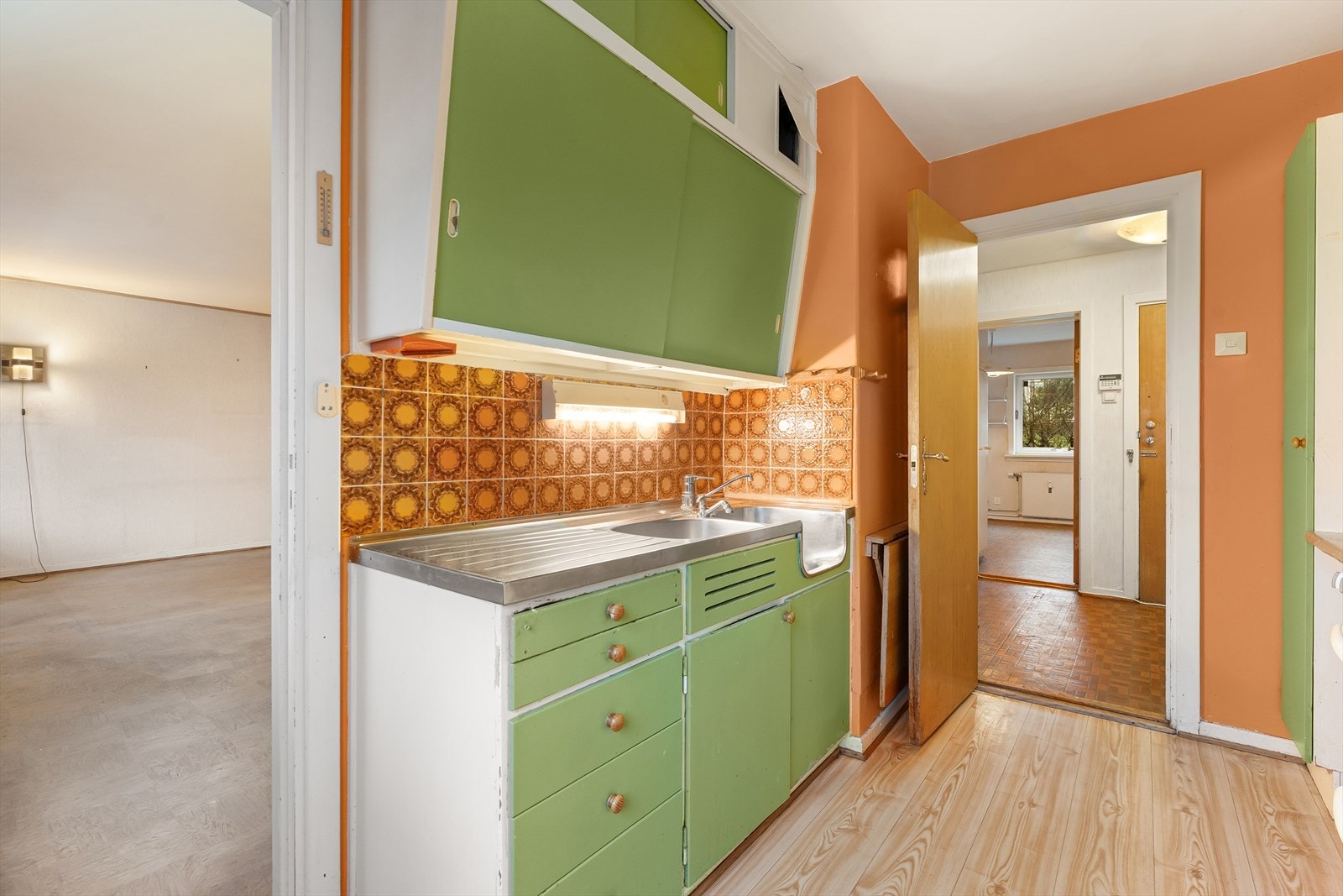 Delvis åpen løsning mellom kjøkken og stue. Flere i sameiet har åpnet veggen mellom stue/kjøkken. Galleribilde