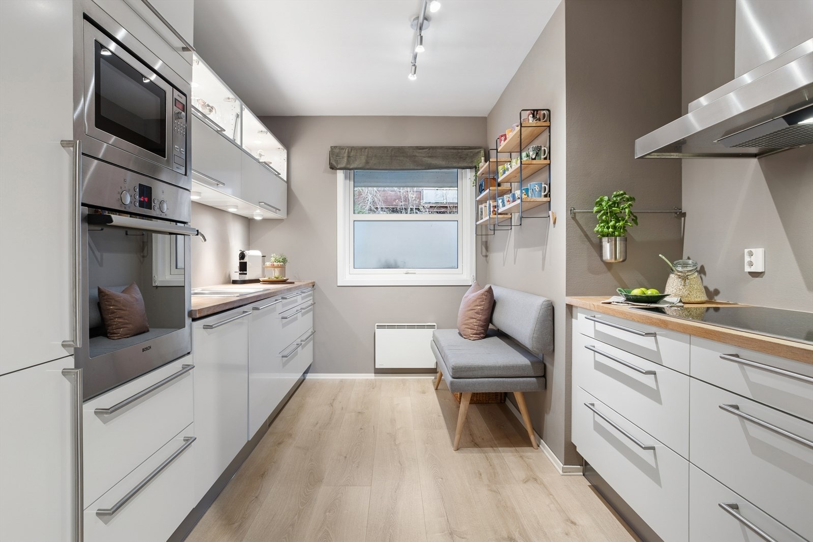 Det er overskap med glassfelt og belysning. Kjøkkenet er utstyrt med integrerte hvitevarer som stekeovn, mikrobølgeovn, oppvaskmaskin, platetopp med induksjon og et kjøleskap med frysedel. Galleribilde