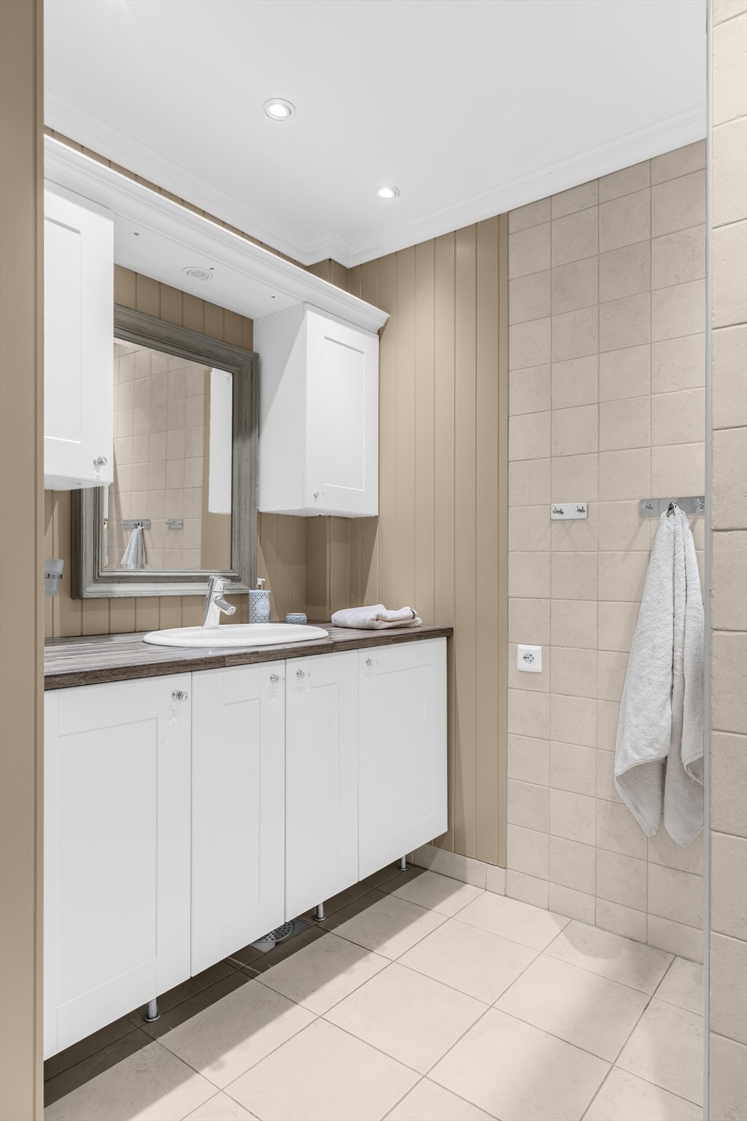 Innredningen består av servant med underskap, overskap, speil med belysning, dusjhjørne med skyvedør i herdet glass samt vegghengt toalett. Galleribilde