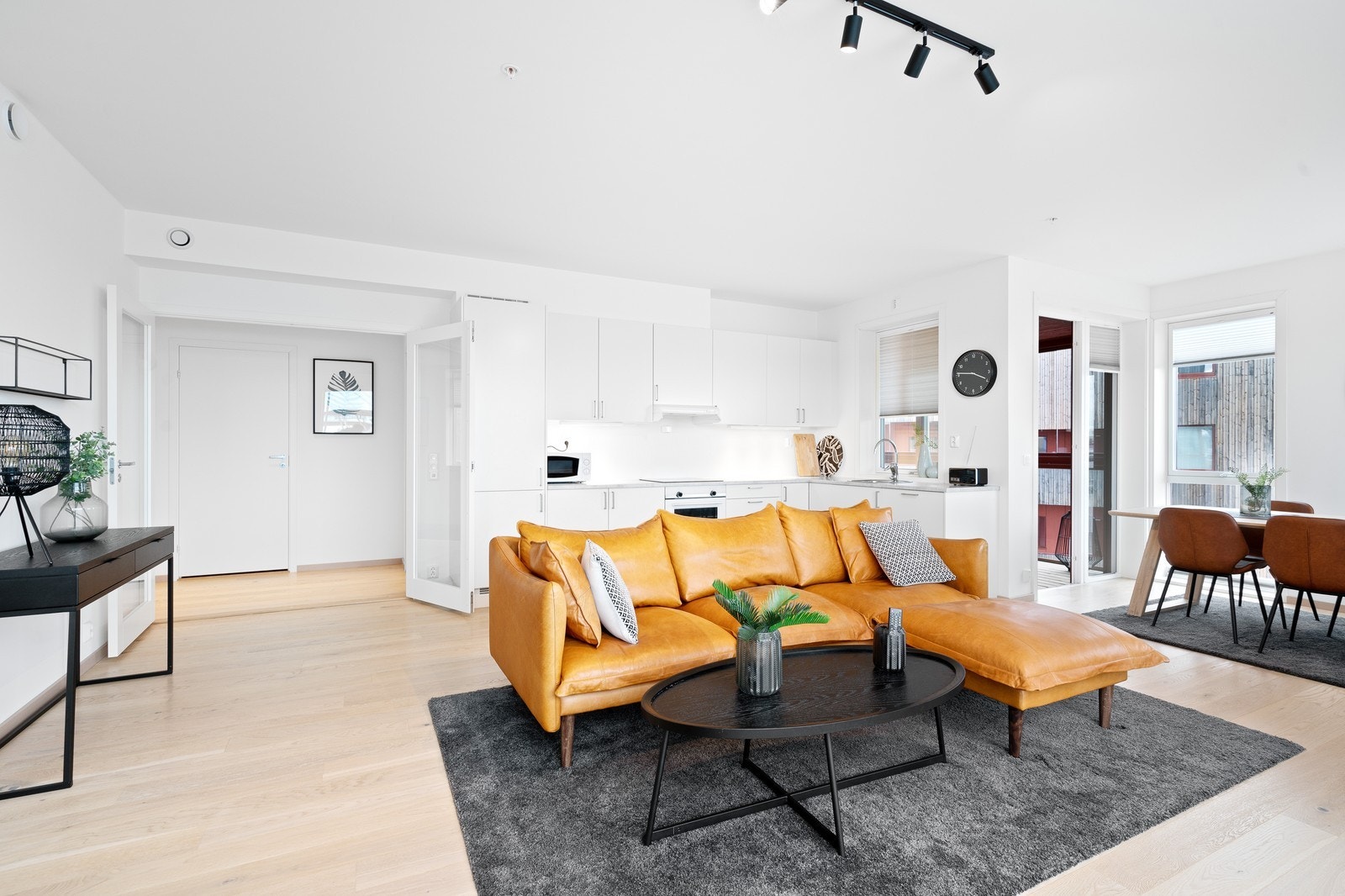 Stue og kjøkken i åpen løsning med spiseplass og utgang balkong Galleribilde