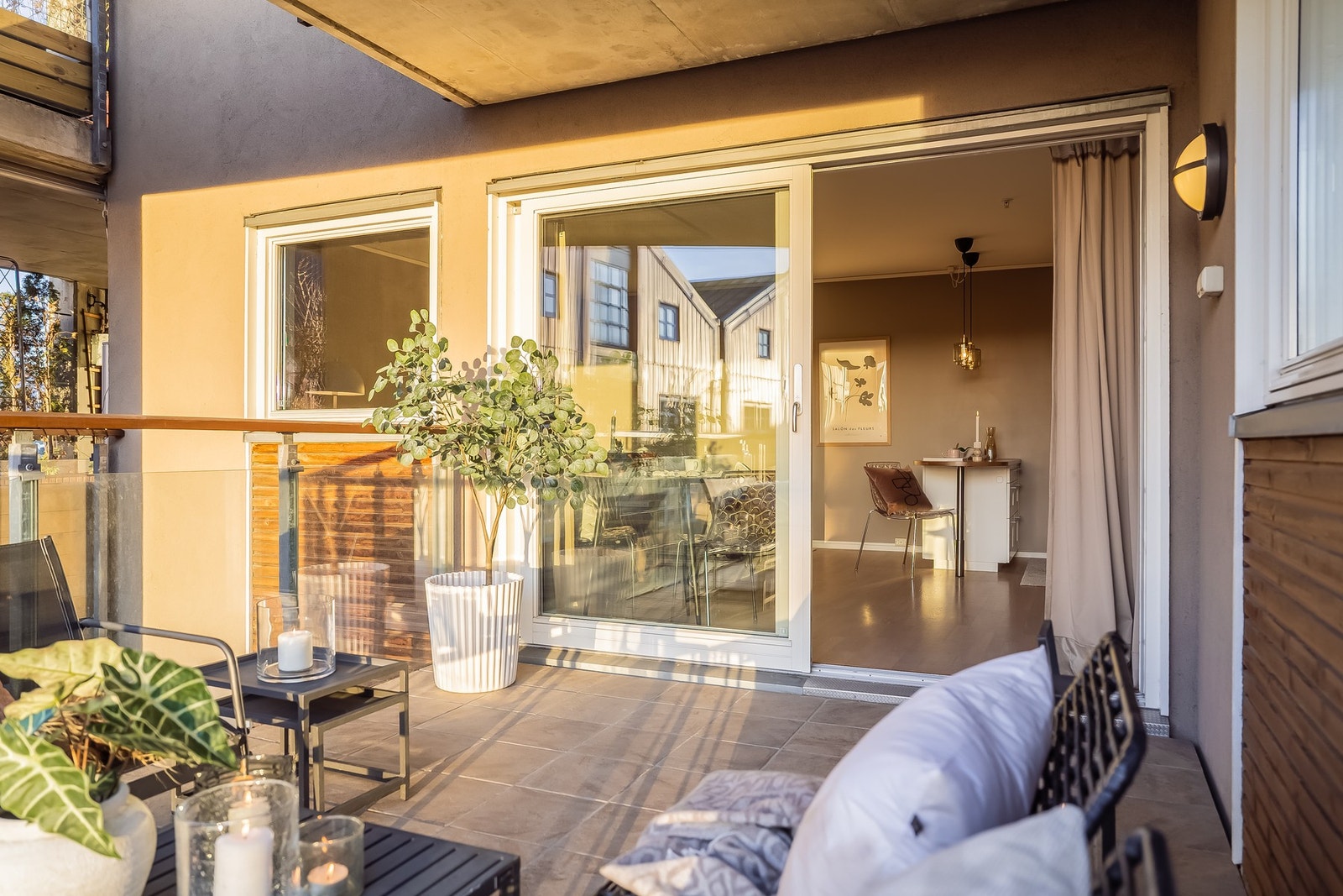 Romslig, flislagt balkong med moderne rekkverk i glass. God plass for sittegrupper, bord, stoler, grill m.m. Galleribilde