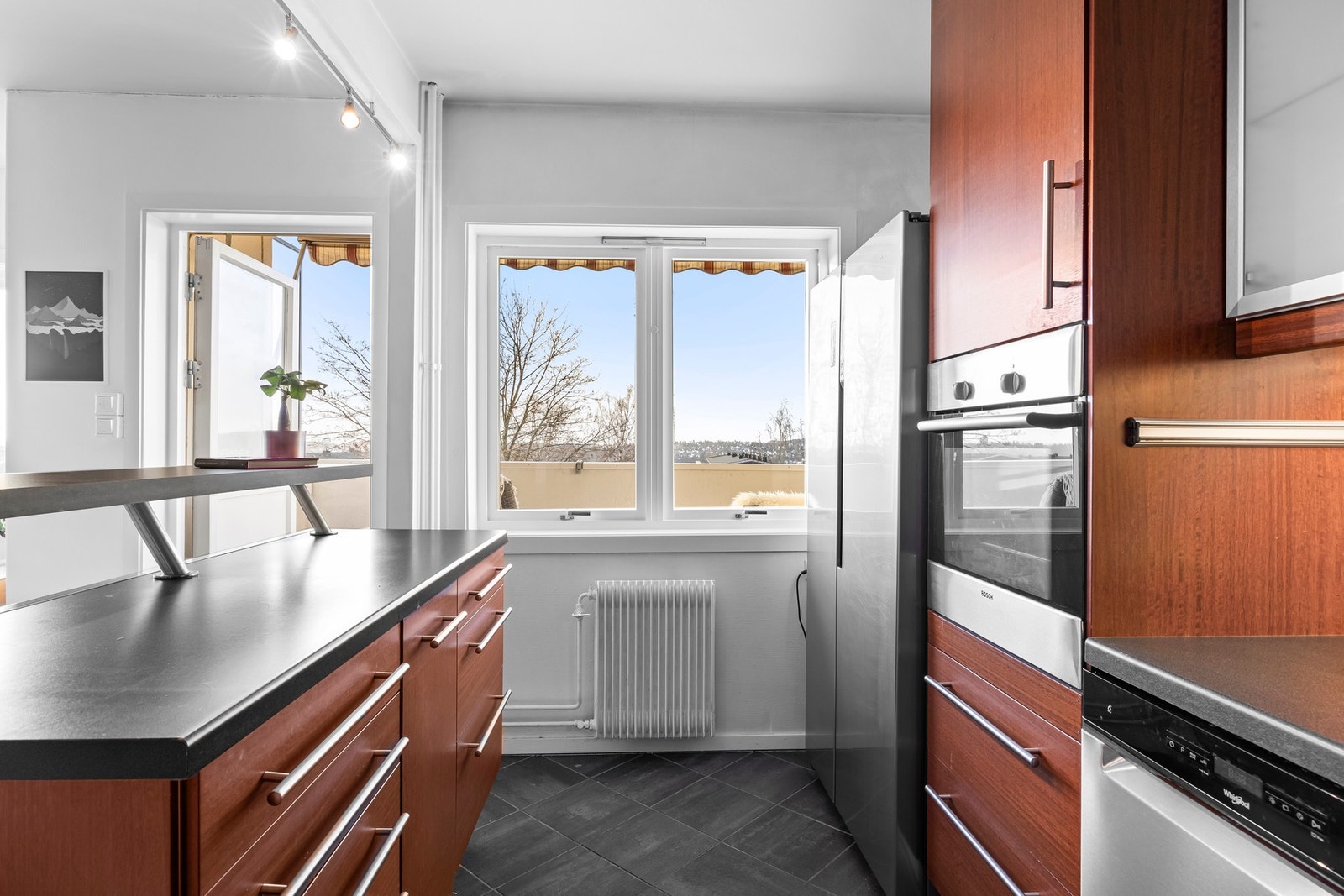 IKEA-kjøkken med god skapplass og bra med arbeidsbenk. Kjøkkenøya bidrar til begge deler. Galleribilde