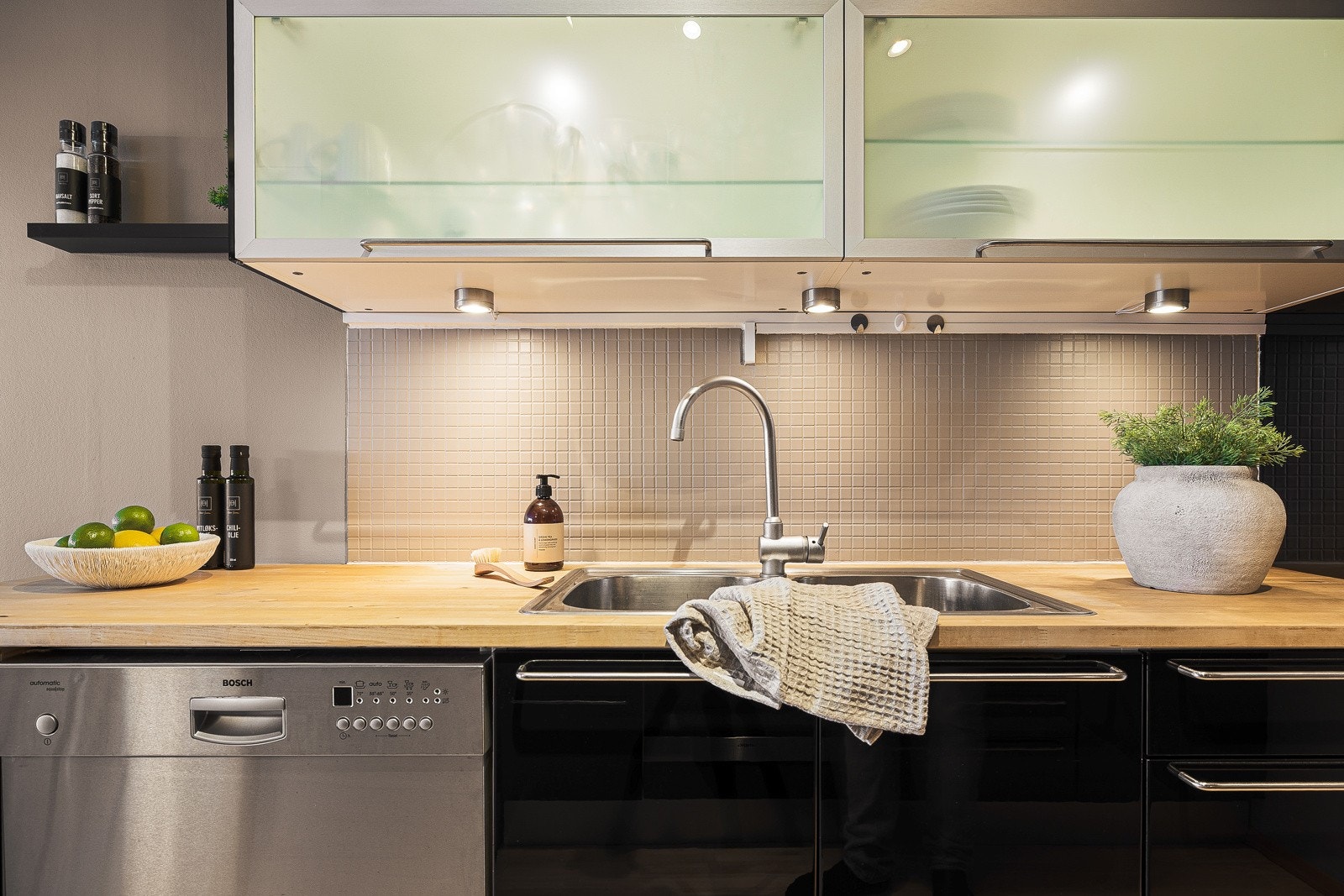 - Det er fliser over benkeplate og lys under overskap - Galleribilde