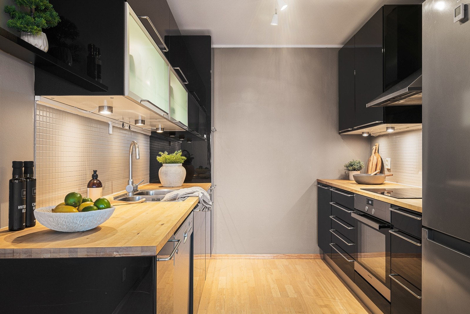 - Det stilrene kjøkkenet har pene høyglansfronter, heltre benkeplate og dels integrerte hvitevarer - Galleribilde