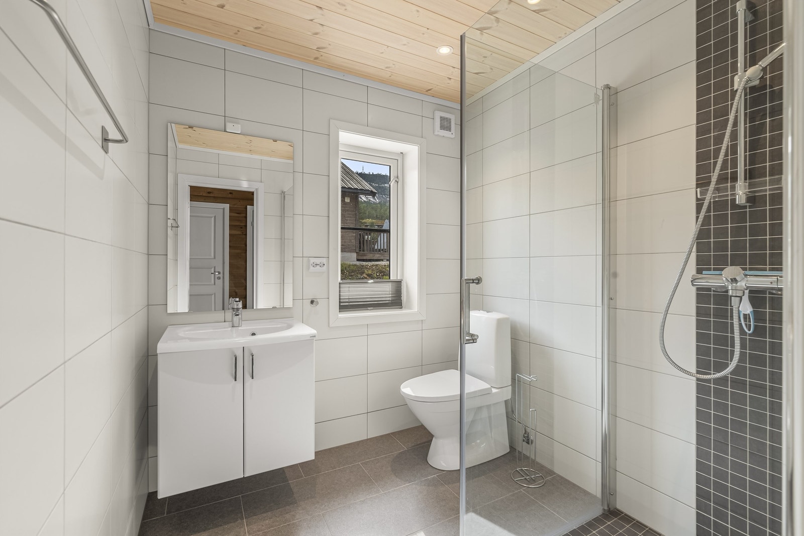 Badet er flislagt med varmekabler og downlights Galleribilde