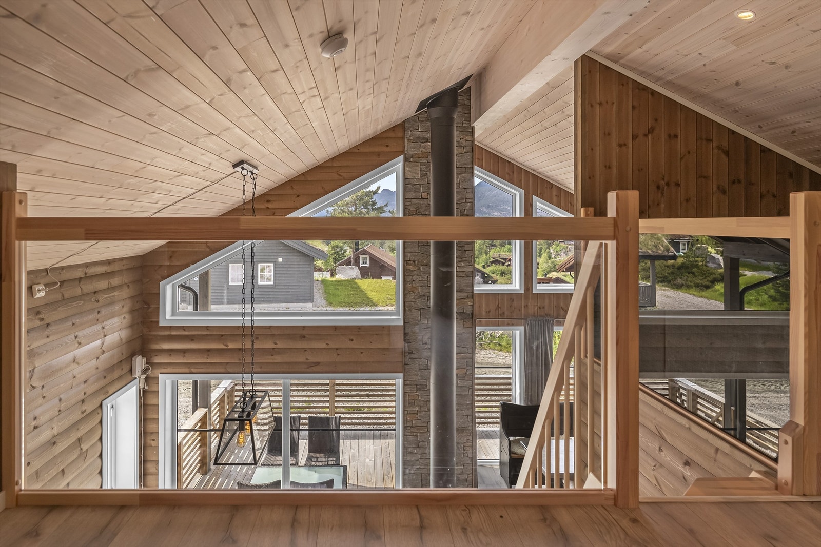 Hemsen har glass-rekkverk ned mot stuen. Galleribilde