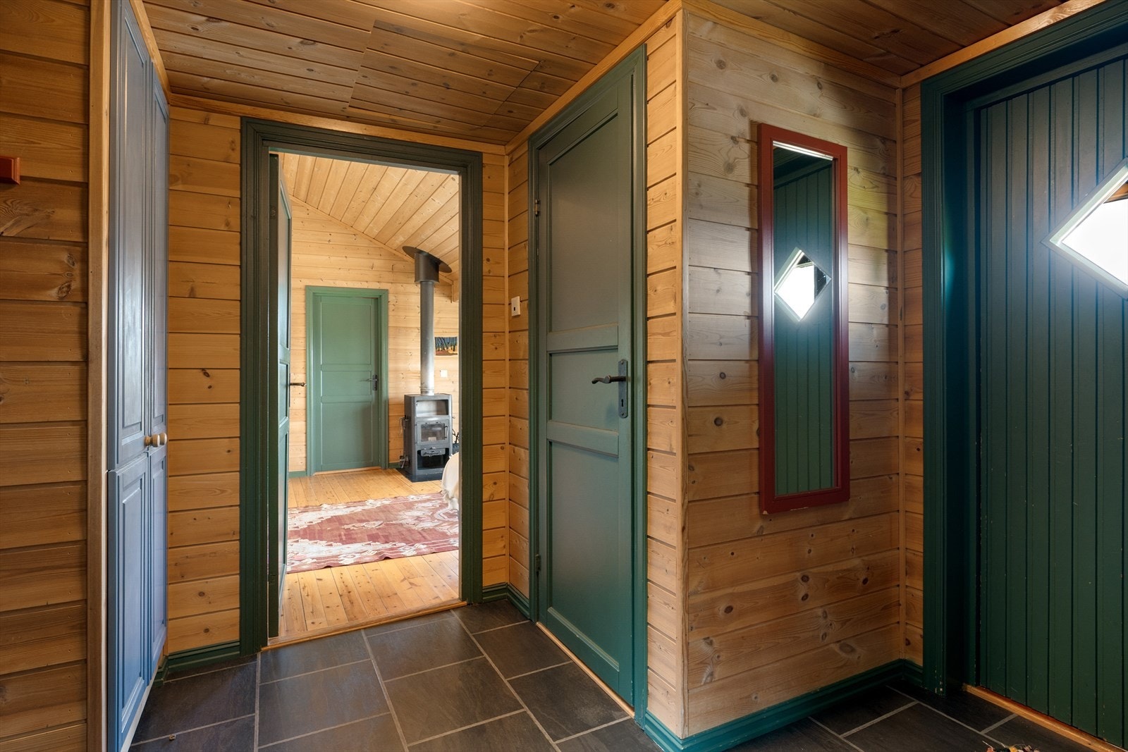 Praktisk entré med flislagt gulv og oppbevaringsplass i plassbygd garderobeskap. Galleribilde