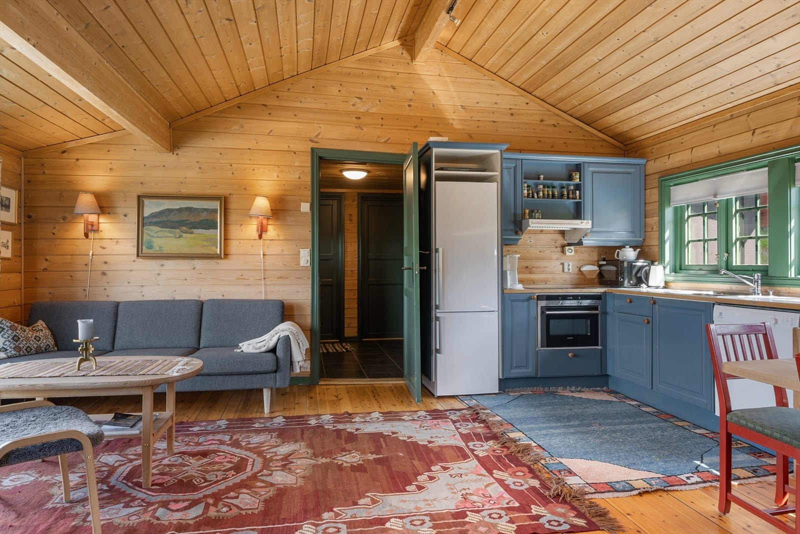 Skråhimlingen bidrar til en luftig og åpen romfølelse i stue og kjøkken. Galleribilde