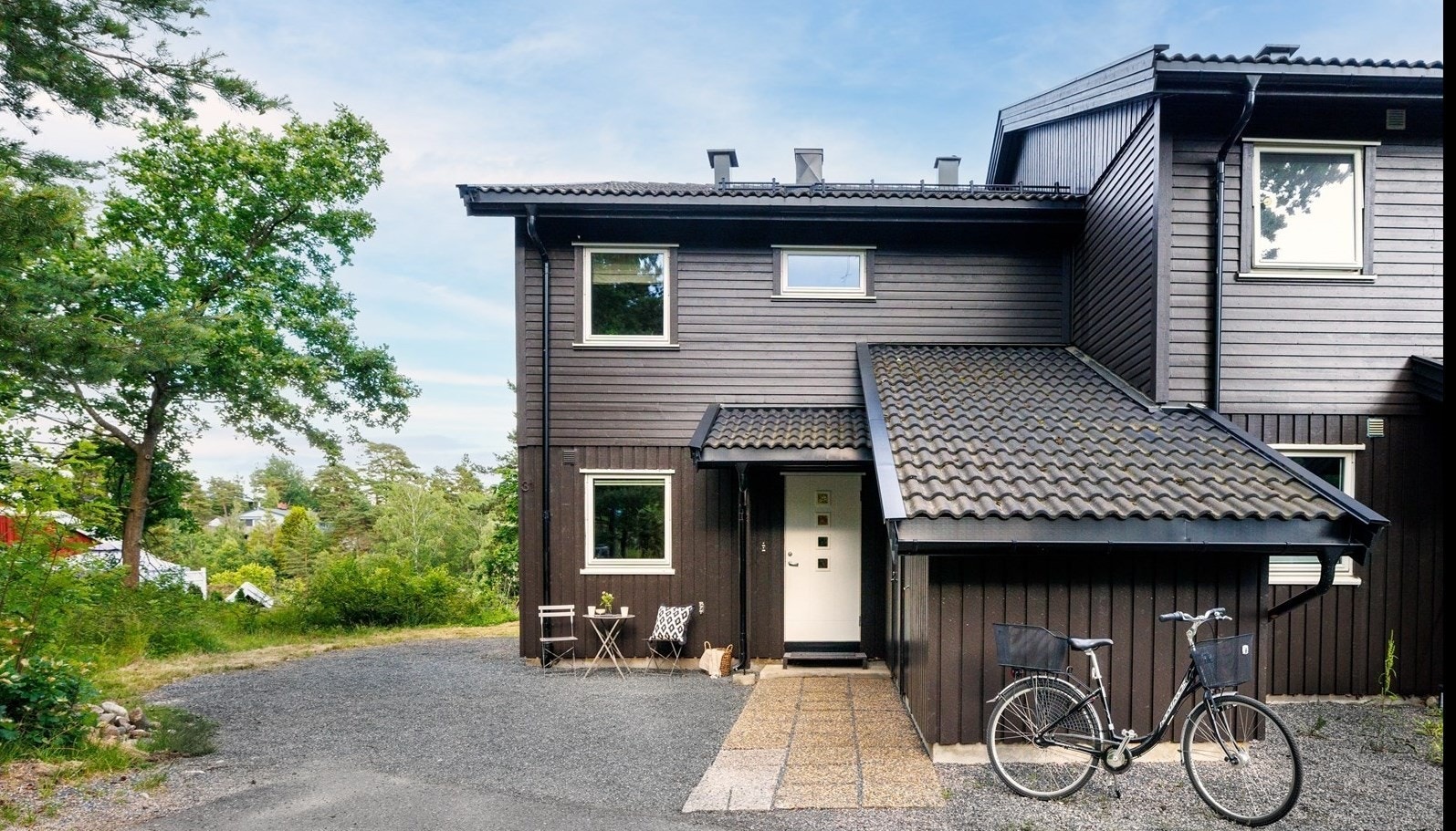 Fasaden fremstår velholdt med liggende panel malt i mørk brunfarge og hvite vinduskarmer. Leiligheten ligger som en endebolig med skjermet plassering og ekstra vindu, og har egen gårdsplass med bod og sitteplass ved inngangspartiet Galleribilde