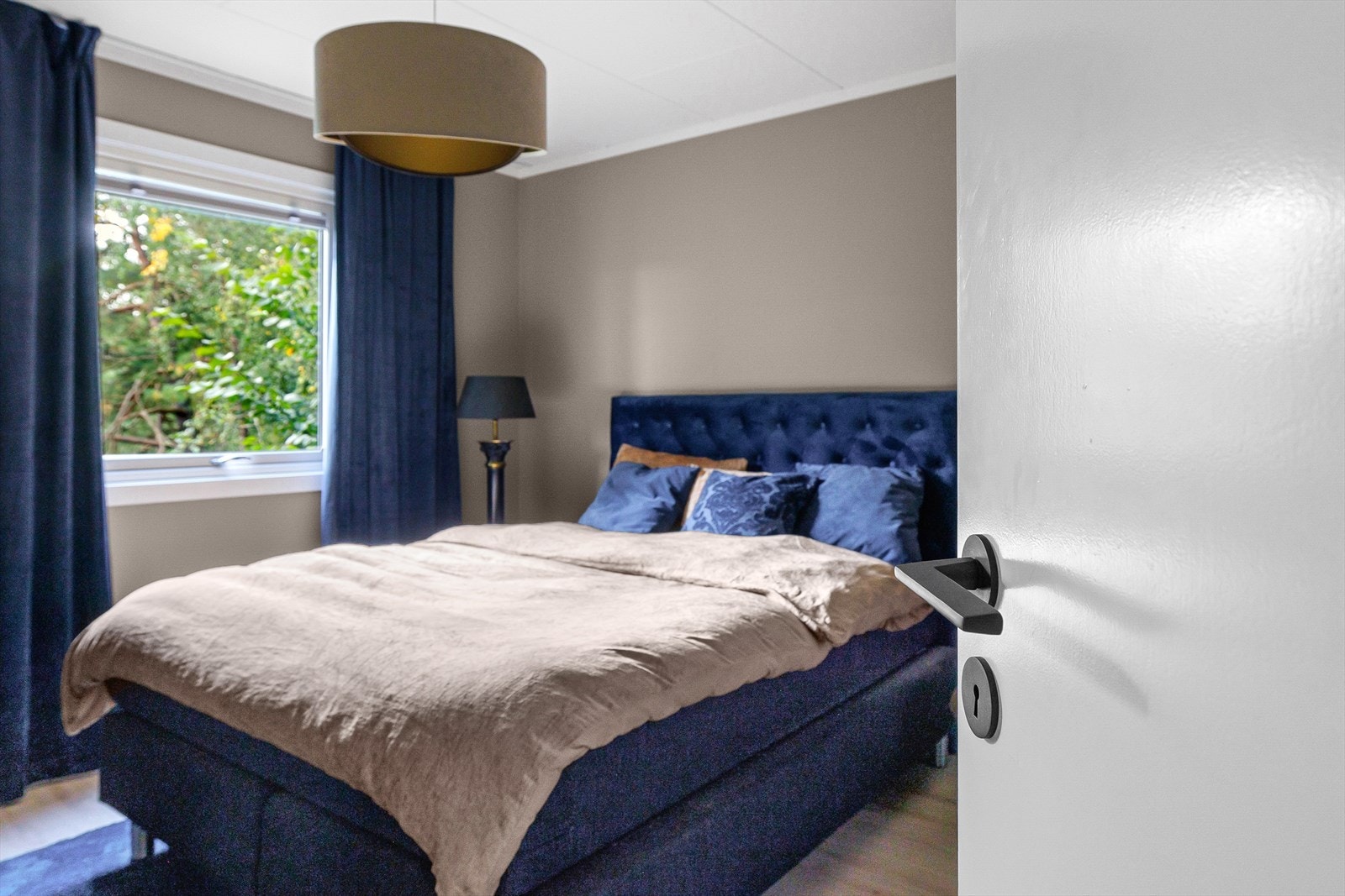 Soverom med god plass til dobbeltseng og garderobeskap. Vinduet vender mot grøntareal, med morgensol og fuglesang rett utenfor. Galleribilde