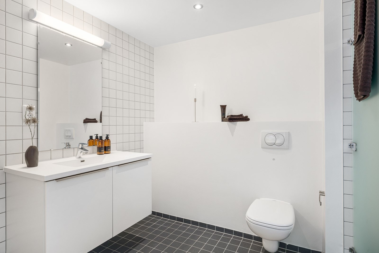 Badet er utstyrt med servant med innredning og vegghengt toalett. Galleribilde