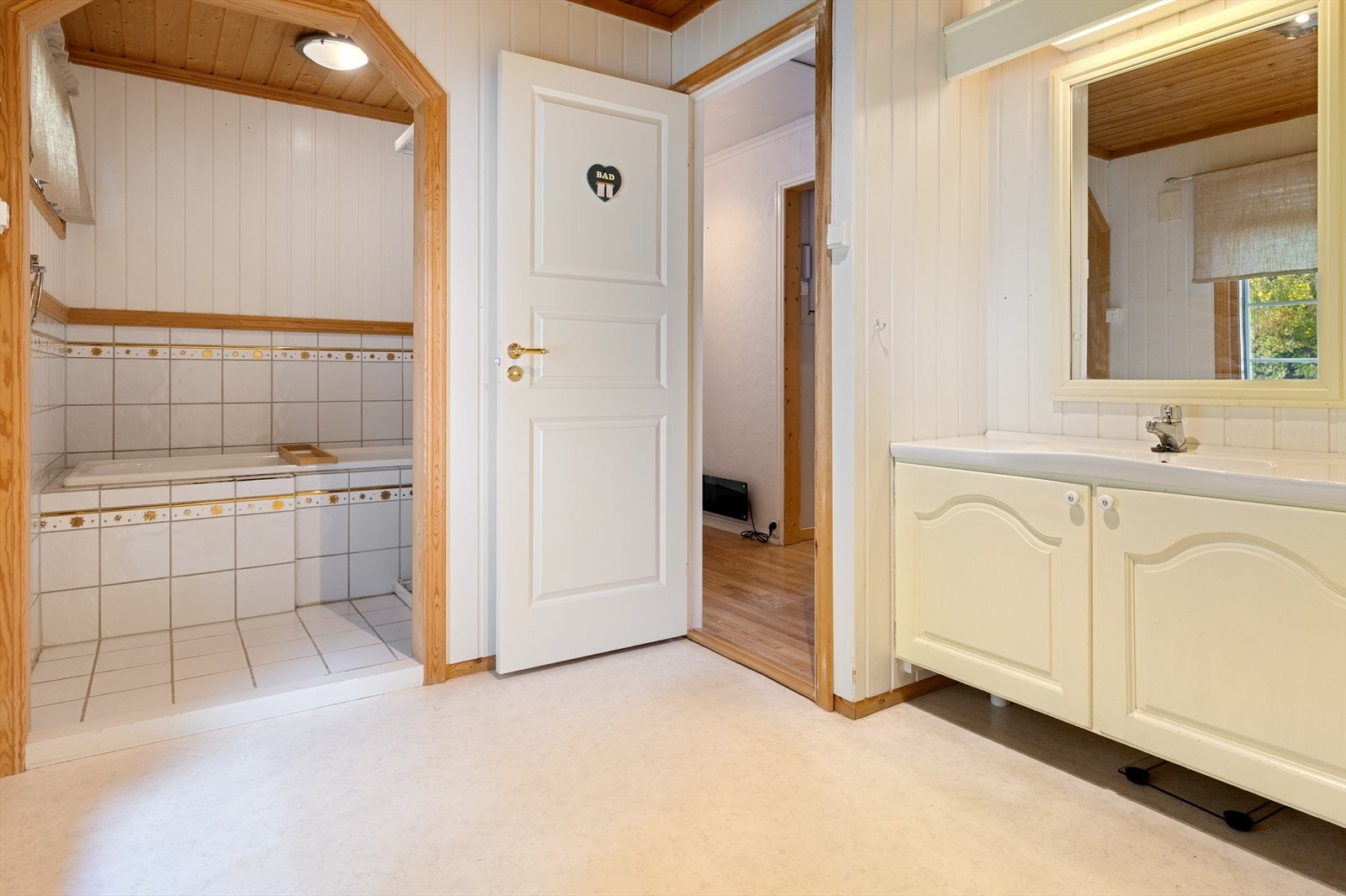 Baderommet inneholder dusjvegger, badekar, toalett og baderomsinnredning med servant. Galleribilde