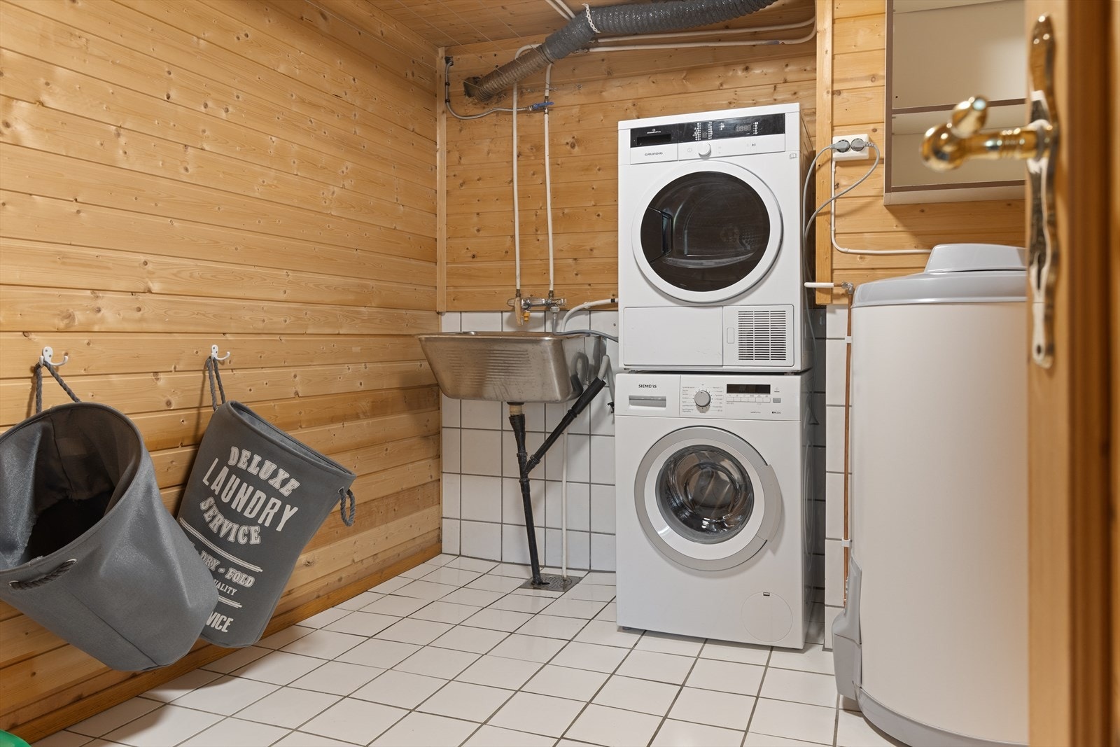 Vaskerommet har flisbelagt gulv, vegger med panel dels flis og panel i himling. Galleribilde