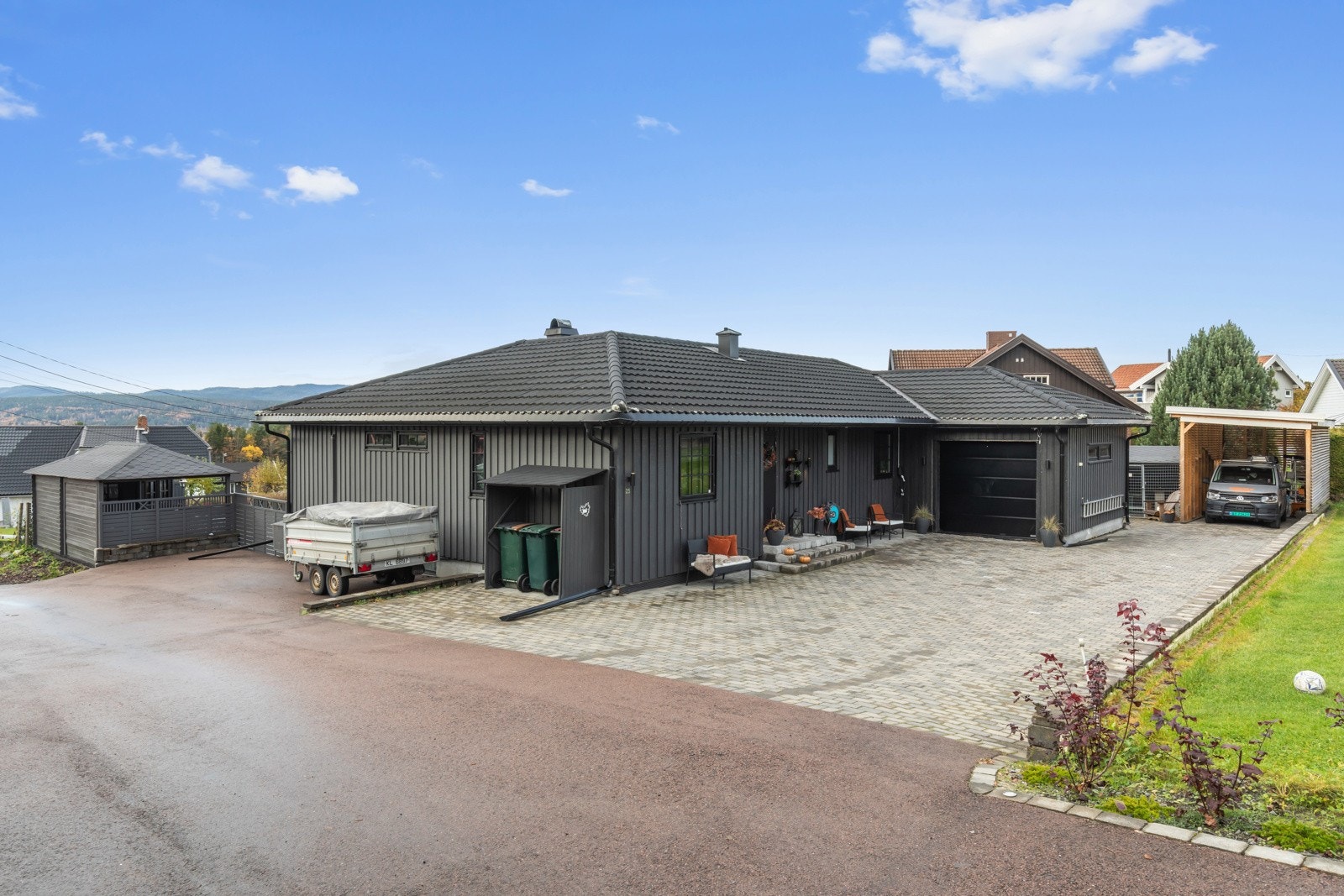 Stor gårdplass med belegningsstein | garasje (19 kvm) og carport | overbygget inngangsparti | god parkering i gårdsplassen og langs enden av huset mot veien Galleribilde