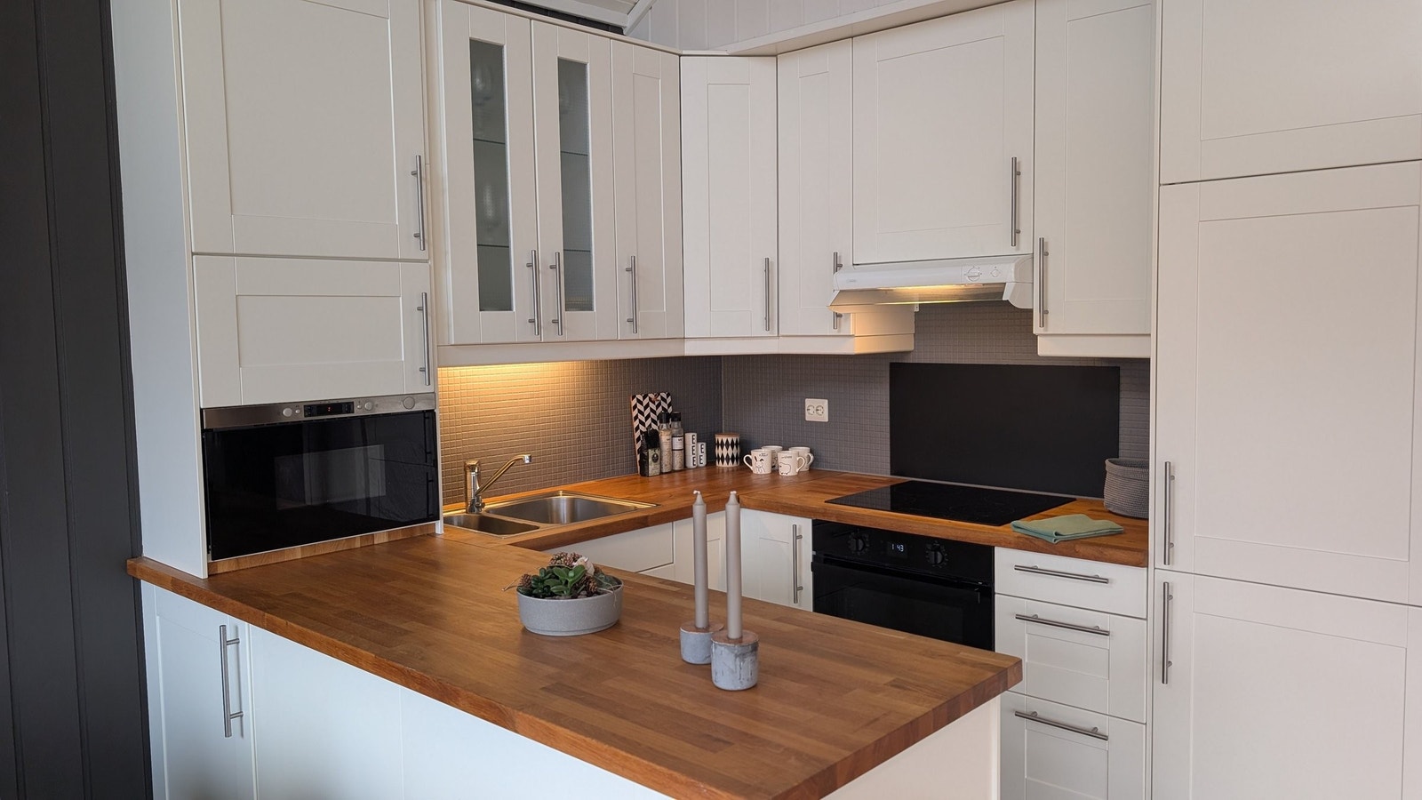 Kjøkken med integrerte hvitevarer (mikrobølgeovn, komfyr, oppvaskmaskin og kjøleskap) Galleribilde