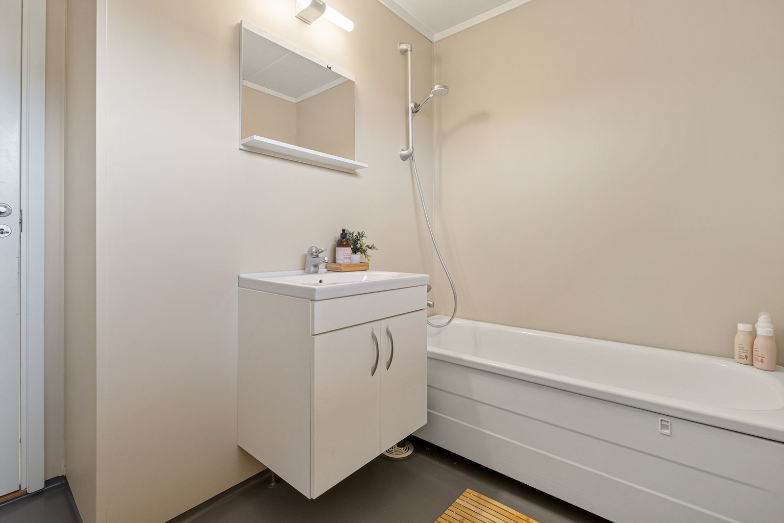 Badet er fra byggeåret 1988 og har belegg på gulvet samt plater på vegger og i tak. Badekar med dusjløsning. Galleribilde