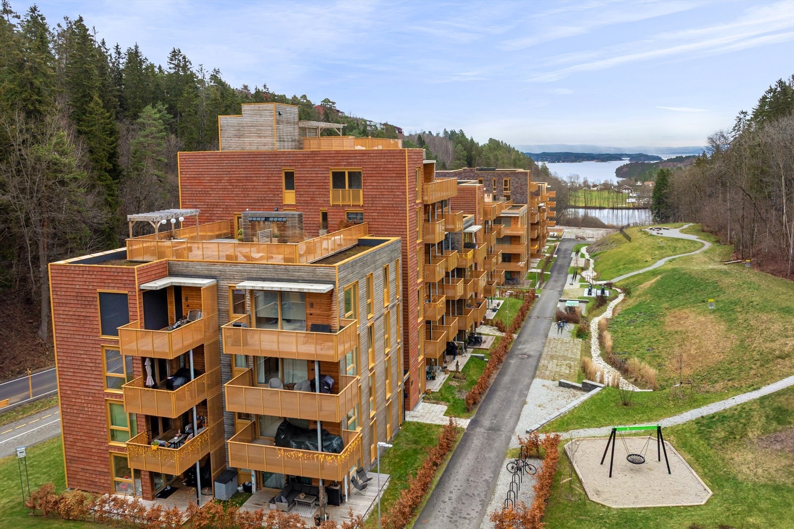 Boligprosjektet er omgitt av skogkledde dalsider og grønne fellesarealer. Galleribilde