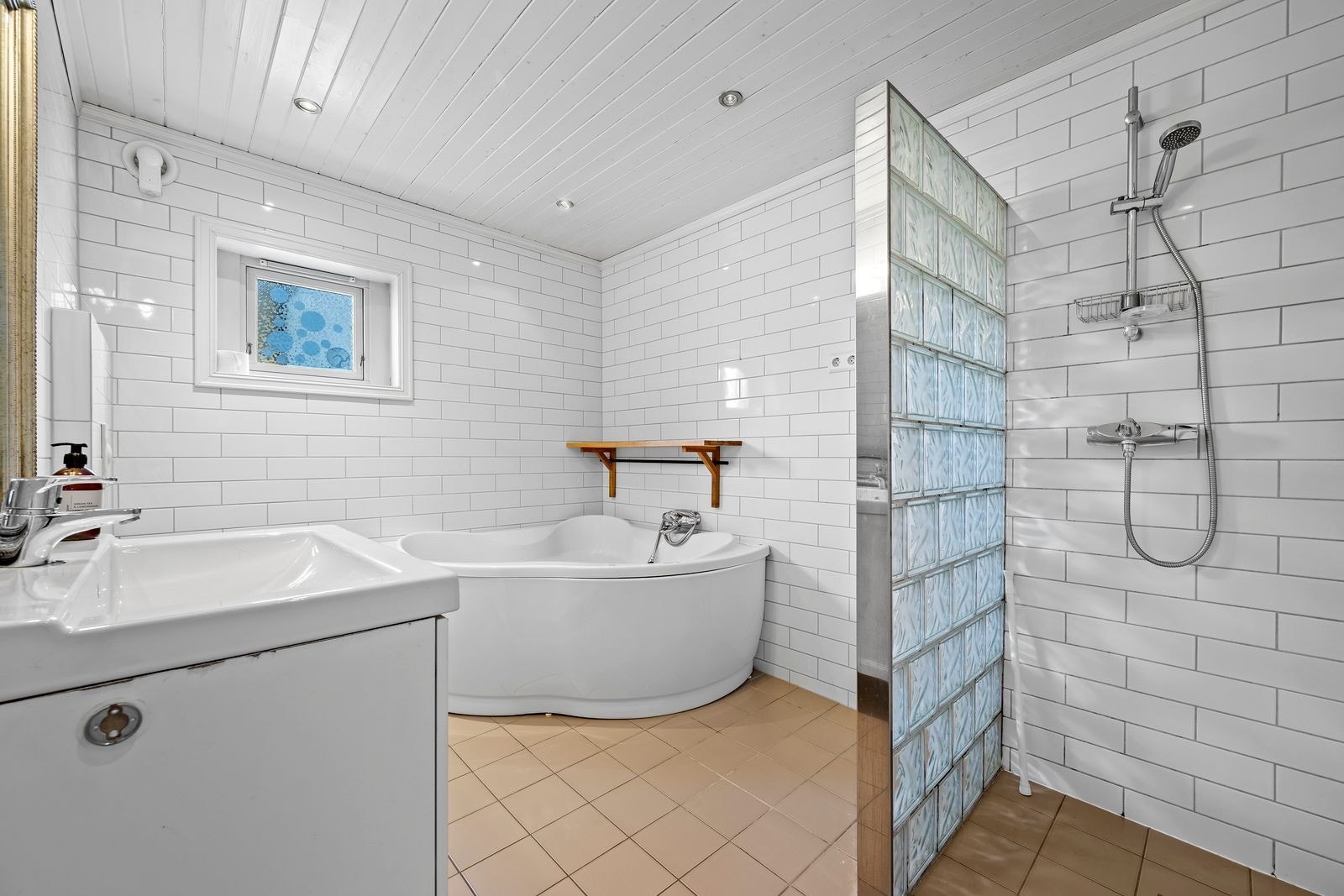 Badet har flislagt gulv og vegger og panel i himling Galleribilde