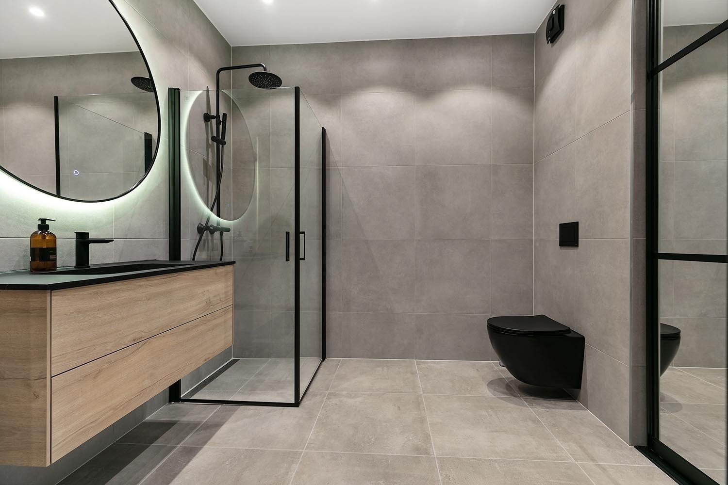 Delikat, flislagt baderom med opplegg for vaskemaskin og tørketrommel. Galleribilde